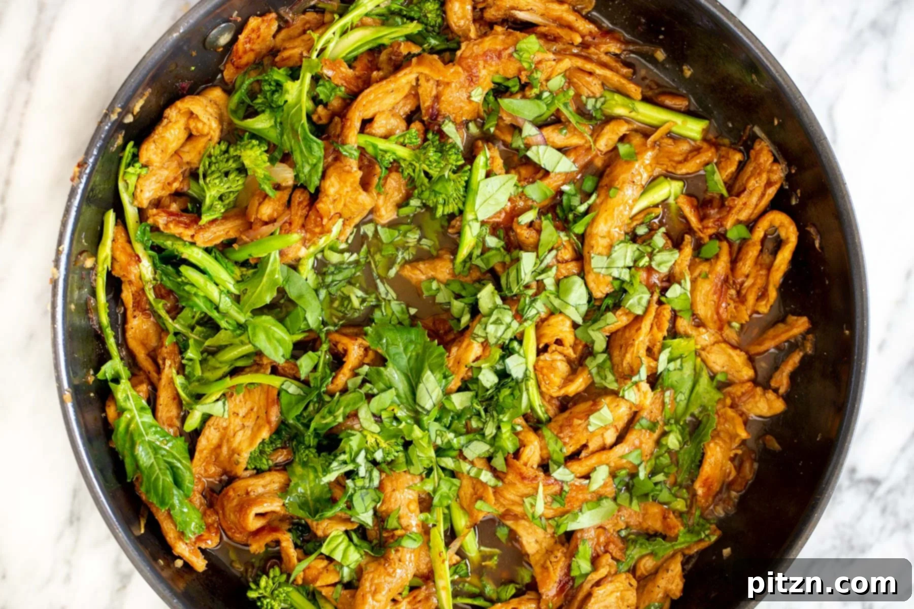 Sesame soy curl stir-fry simmering with broccolini, coated in a rich, thickened sauce
