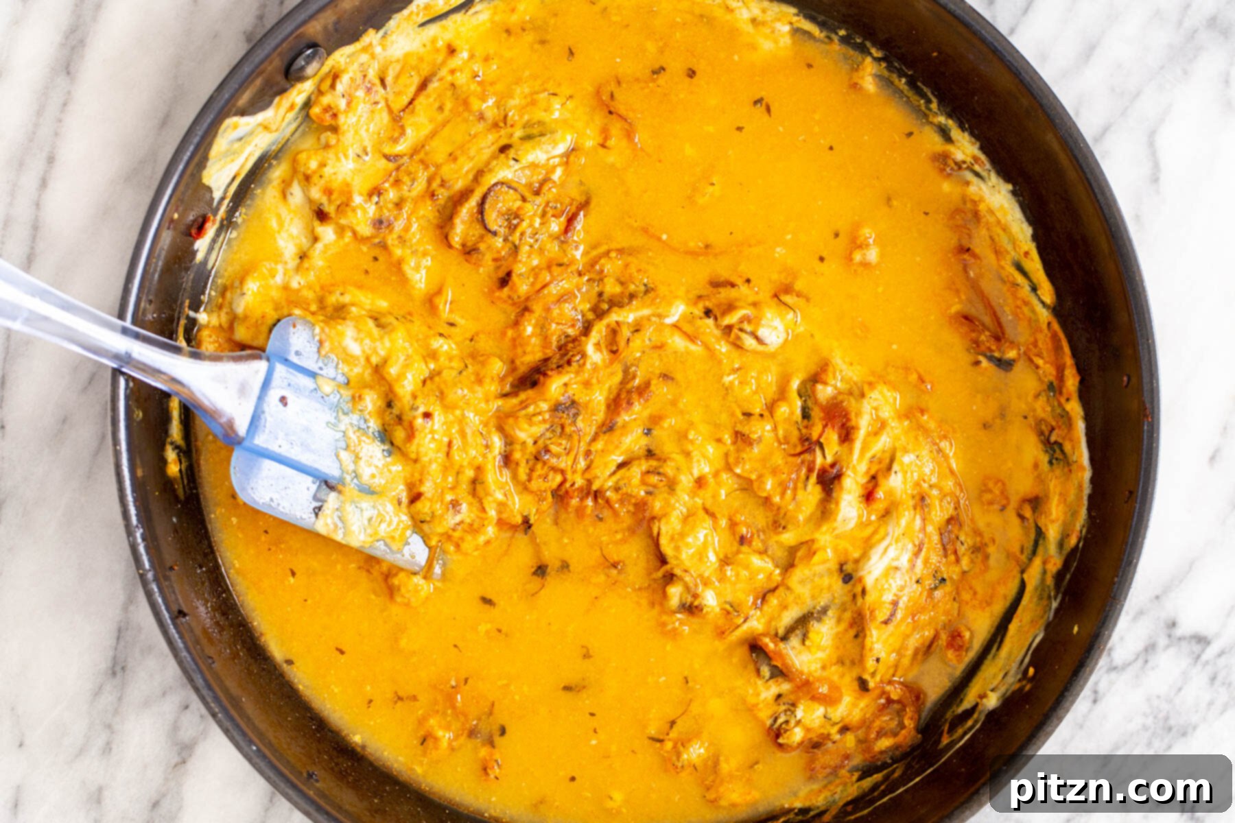 Rich Double Onion Cauliflower 12 A creamy, rich onion gravy, infused with spices and a hint of tomato, simmers invitingly in a black saucepan, ready for the cauliflower.