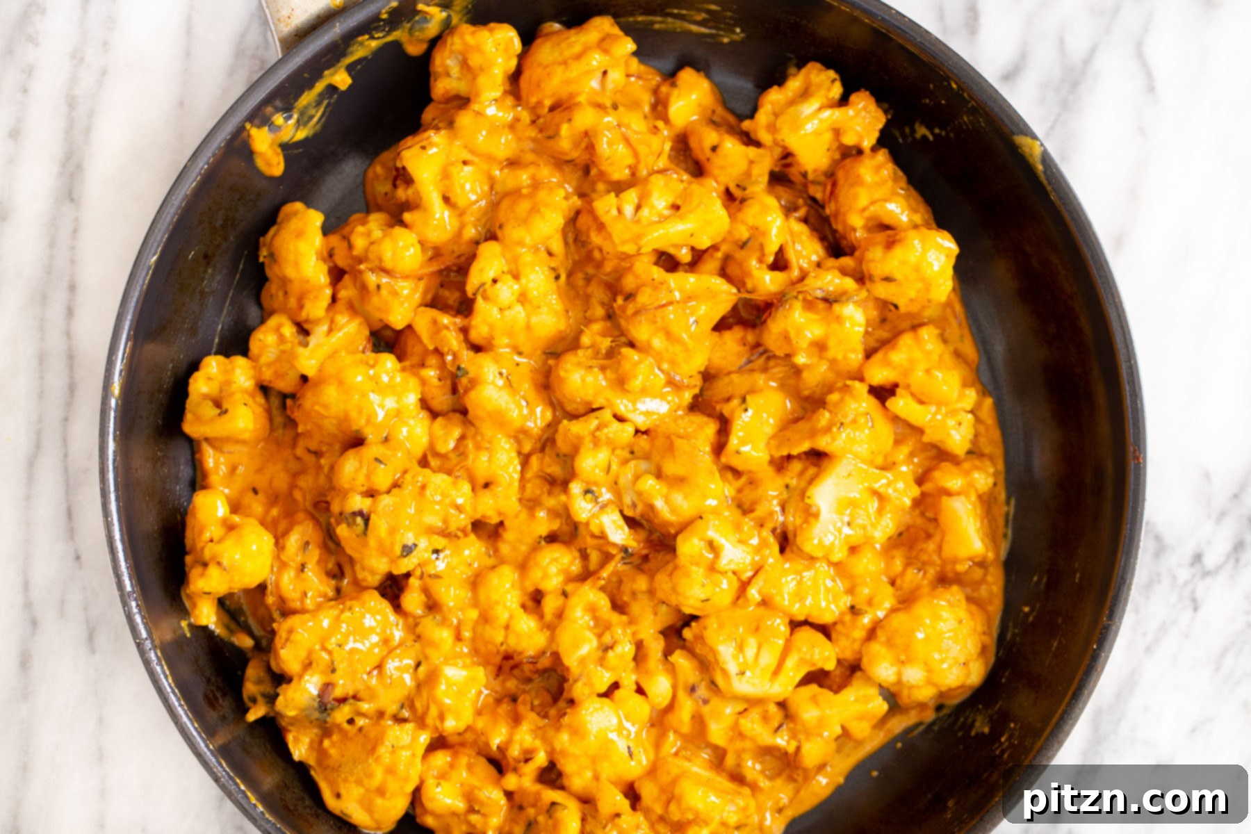 Rich Double Onion Cauliflower 15 Cauliflower simmering gently in a vibrant tomato-yogurt gravy, absorbing the rich Indian spices and flavors, promising a delicious outcome.