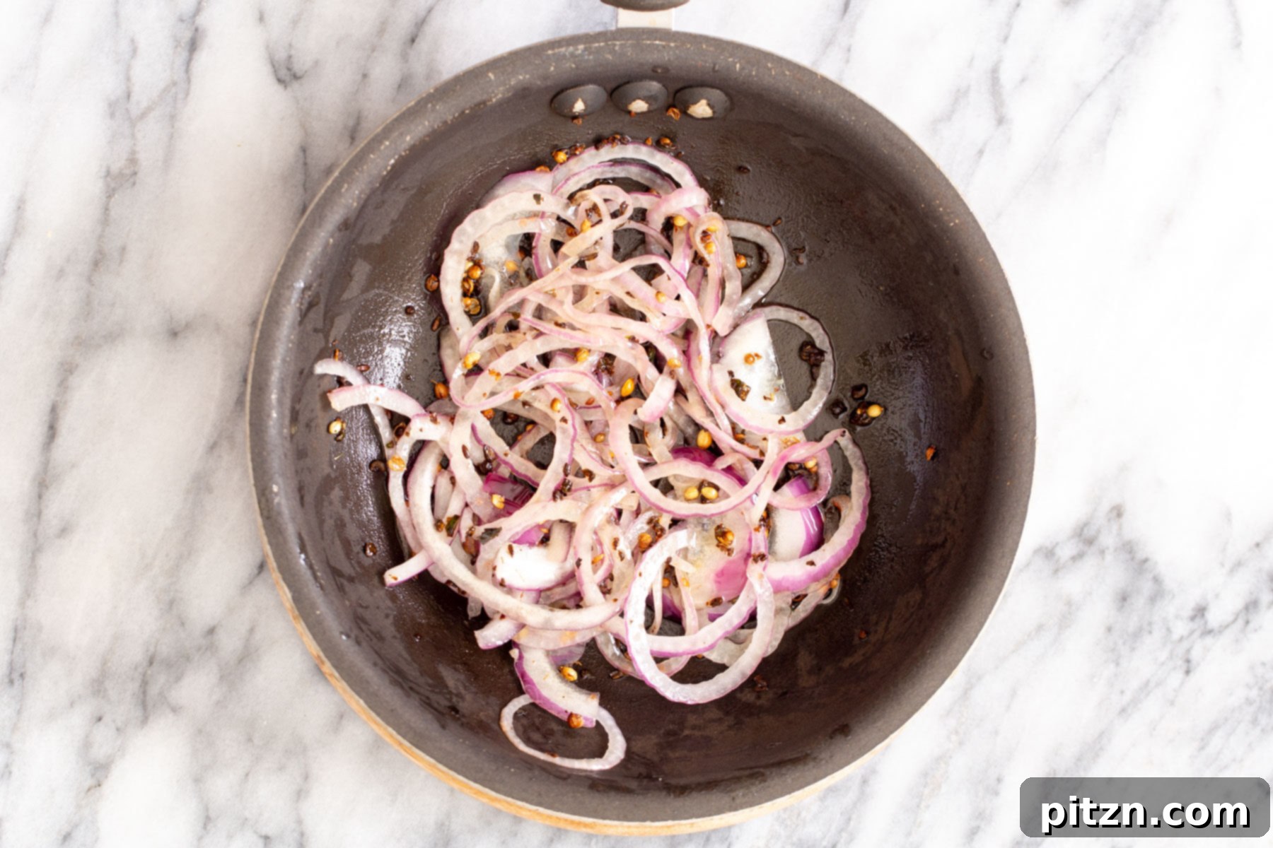 Rich Double Onion Cauliflower 18 Sautéed onions and tempered Indian spices are perfectly golden in a small sautéing pan, forming the aromatic finishing touch for the curry.