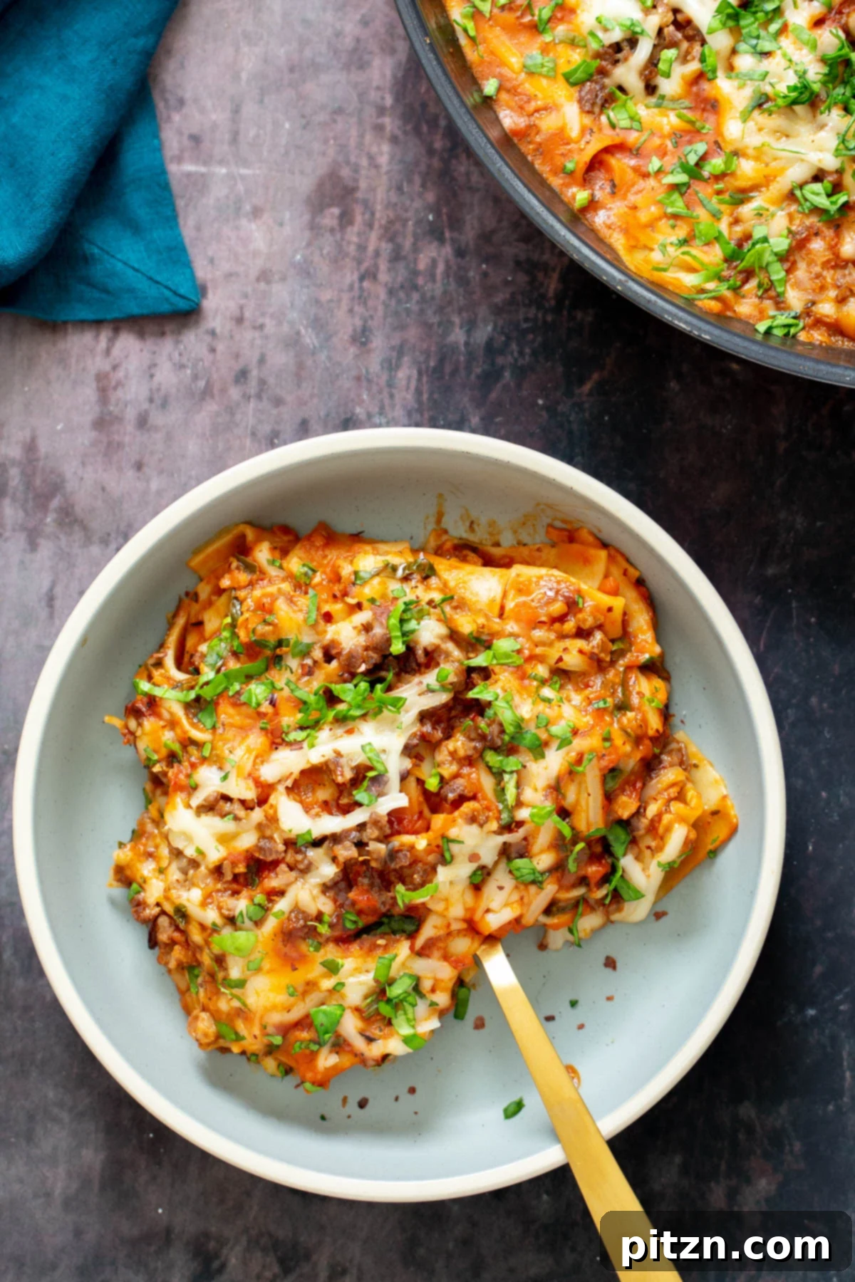 Hearty Vegan Skillet Lasagna 3 A single serving of vegan skillet lasagna on a white plate, garnished with chopped fresh parsley, showcasing the rich sauce and perfectly cooked noodles.