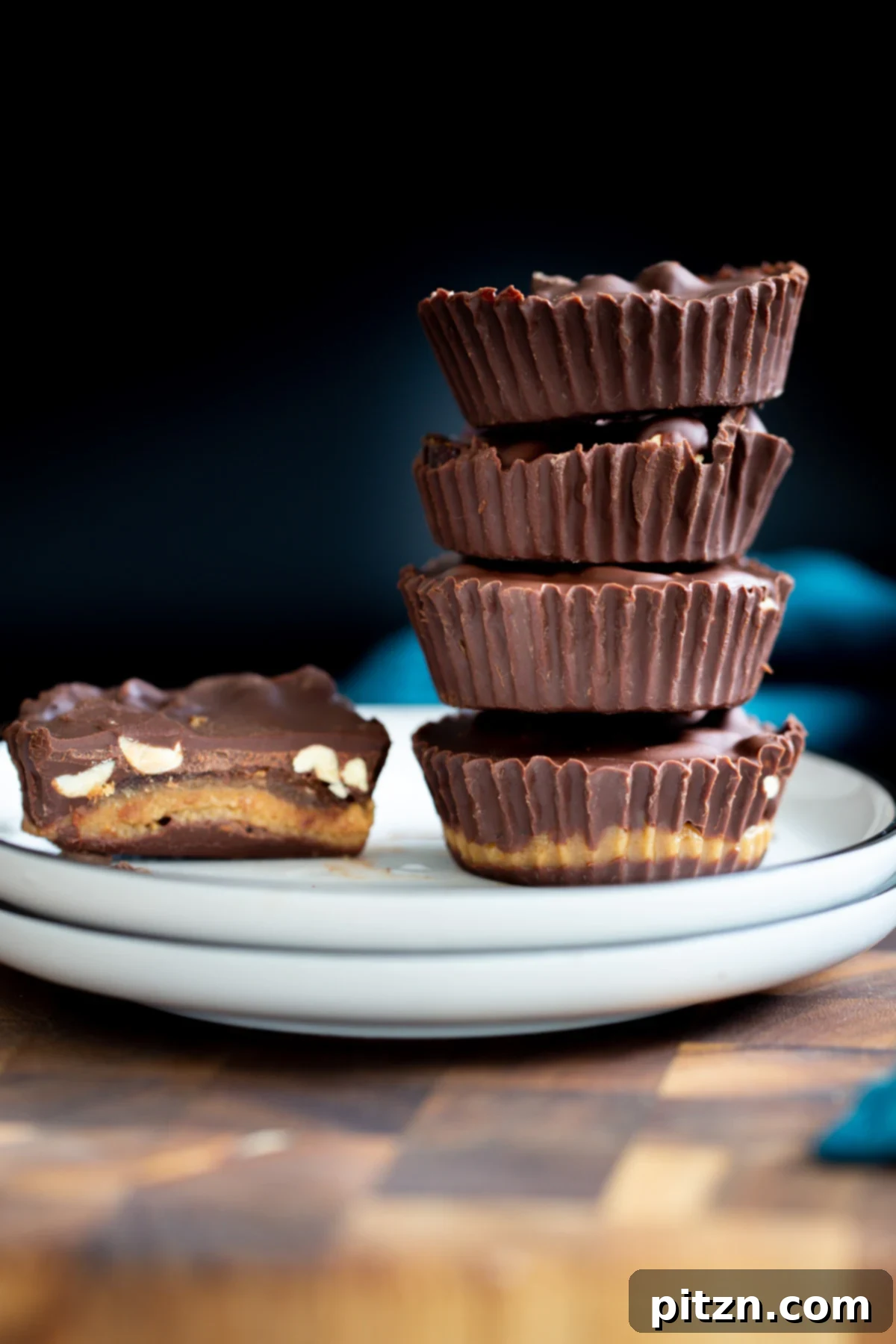 Finished vegan peanut butter snickers cups with dates, presented beautifully against a dark background, highlighting their rich colors and textures.