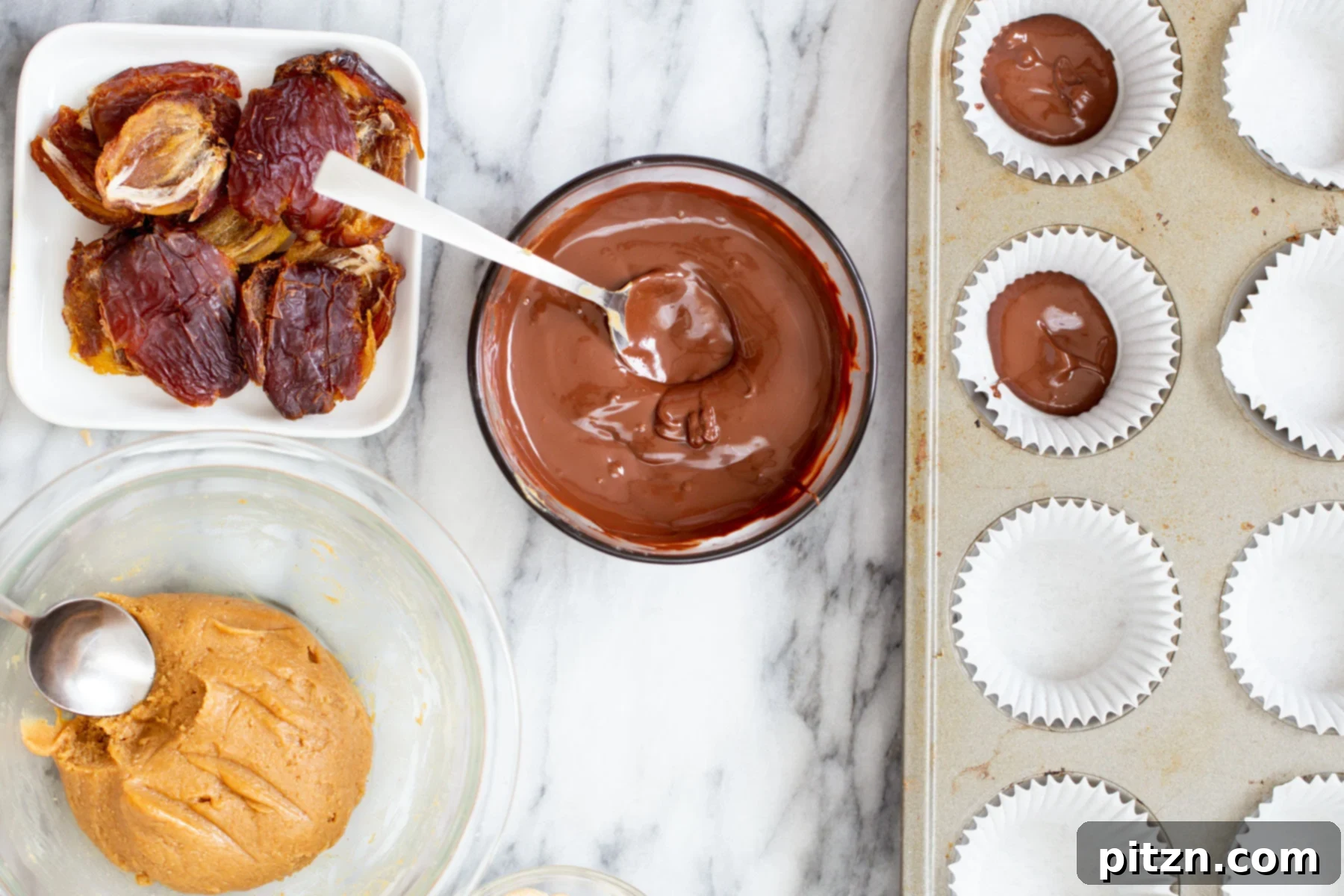 Melted chocolate being carefully spread into muffin molds, creating the base layer for vegan snickers cups.