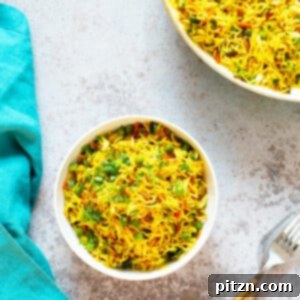 A bowl of curry fried rice on a work top with forks next to it