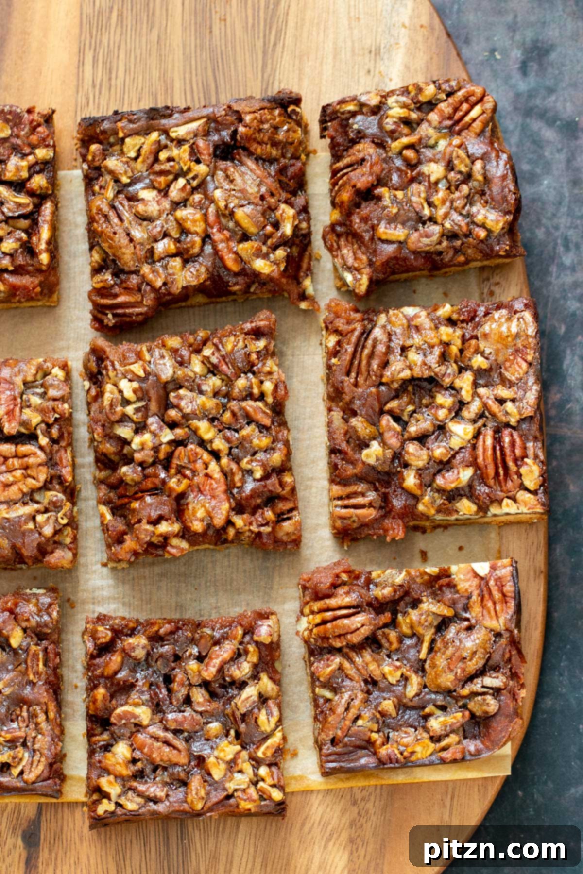 Sliced Pecan Pie Bars Perfectly sliced pecan pie bars arranged on a wooden chopping board, revealing their delicious layers.