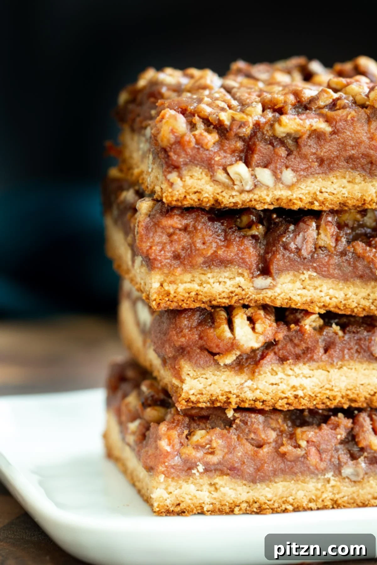 Irresistible Vegan Pecan Pie Bars A stack of golden-brown vegan gluten-free pecan pie bars, ready to be enjoyed, showcasing their tempting layers.