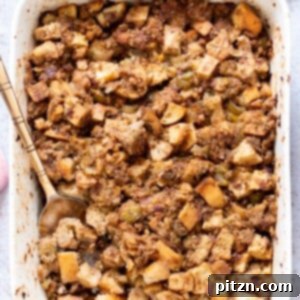 Close-up of baked vegan stuffing with crispy topping in a white dish.