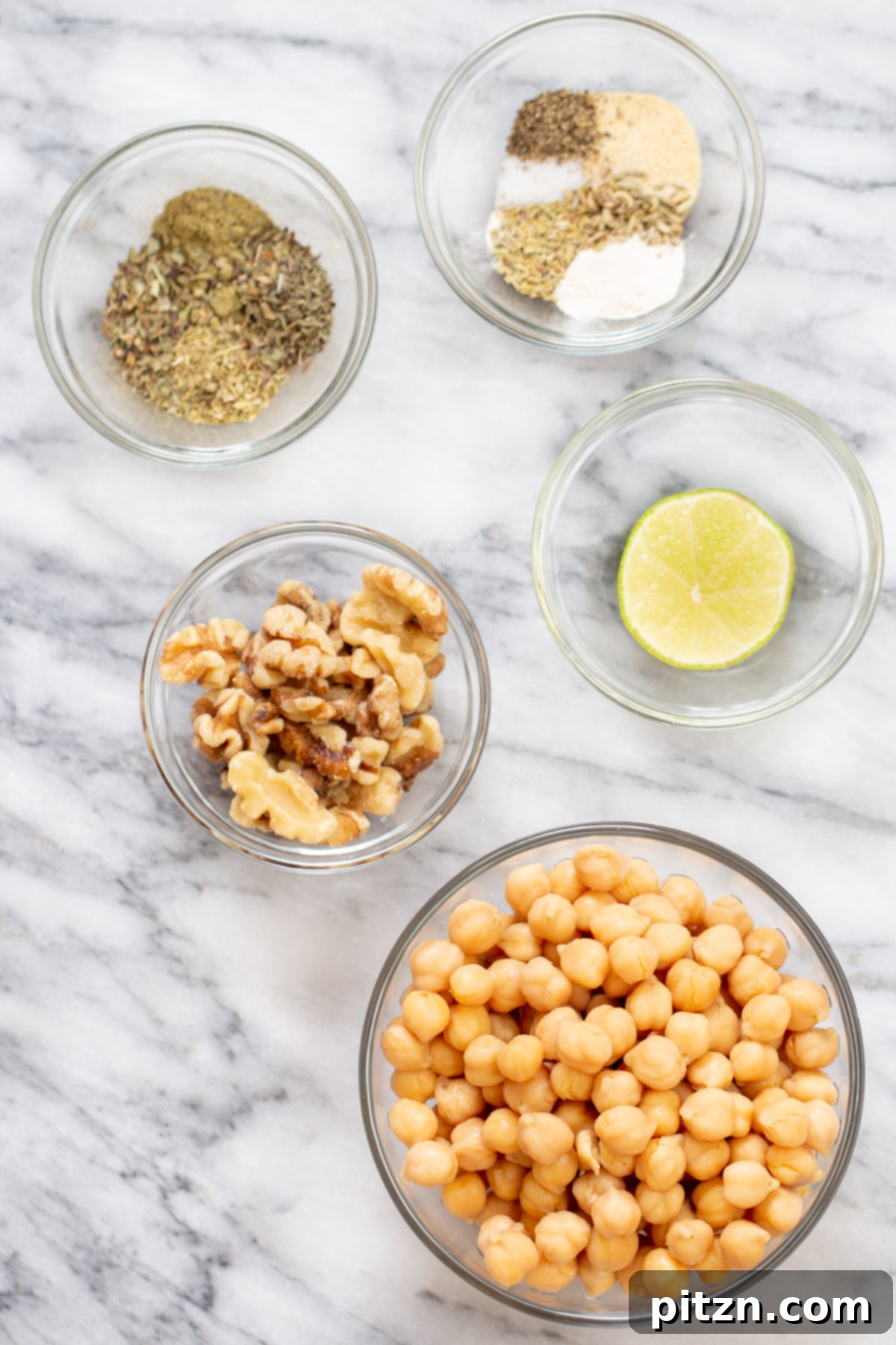 Various whole and prepped ingredients for making vegan chickpea sausage arranged on a wooden board.