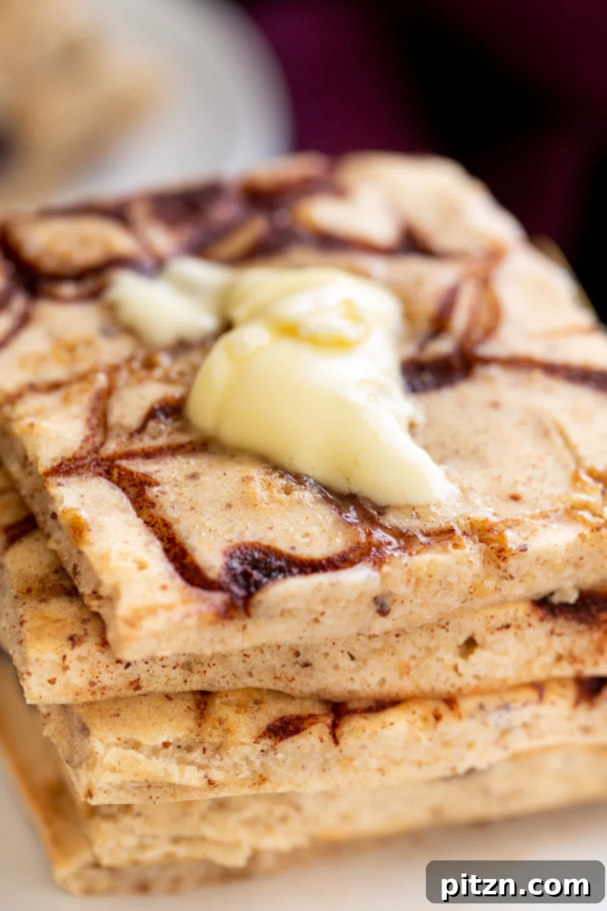 Easy Vegan Sheet Pan Pancakes 2 vegan cinnamon swirl sheet pan pancakes topped with a dollop of vegan butter