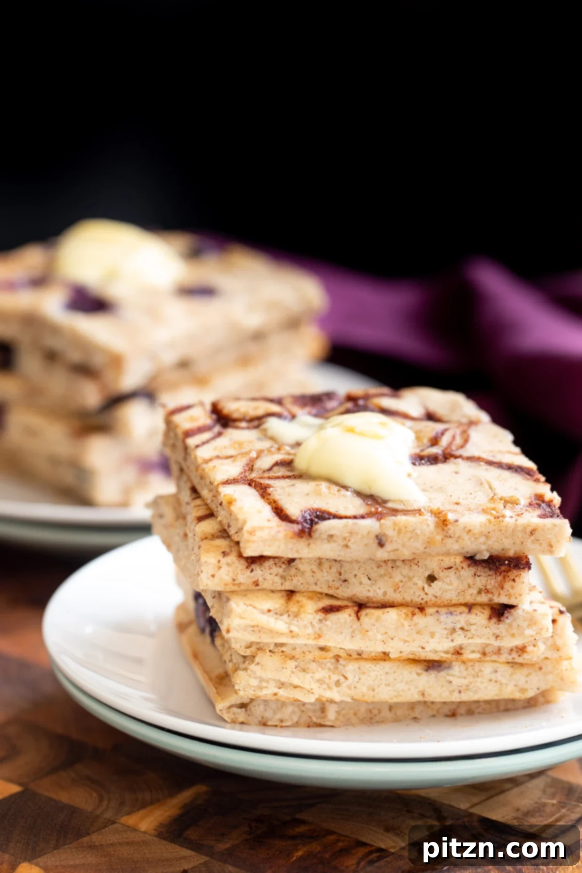 vegan sheet pan pancakes vegan cinnamon swirl sheet pan pancakes stacked on a white plate