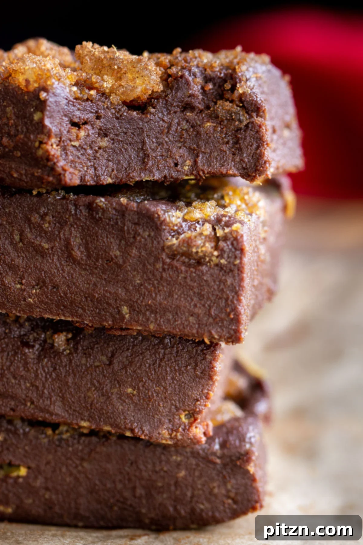 stacked vegan gingerbread fudge topped with brown sugar and candied ginger