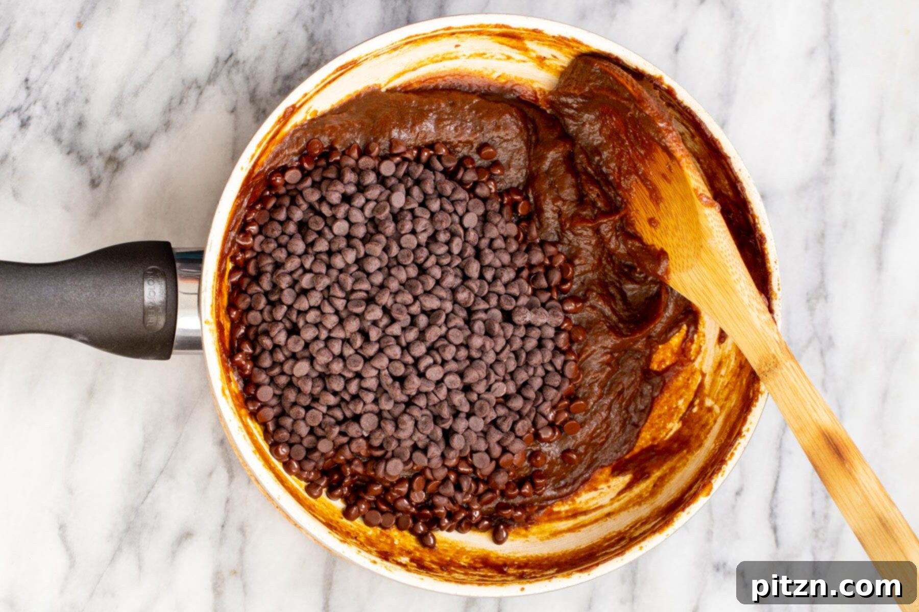 chocolate chips and pumpkin puree in a small pot on a marble surface