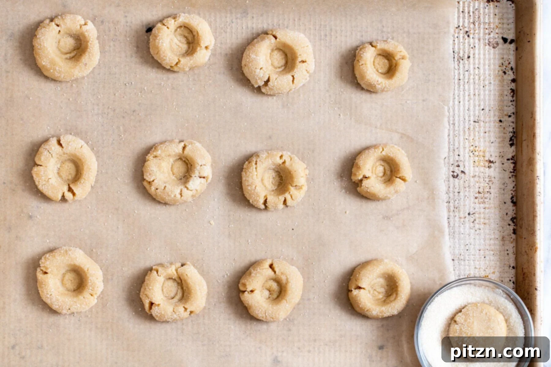 Divine Vegan Gluten-Free Chocolate Thumbprints 4 Unbaked vegan gluten-free thumbprint cookies with indents on a baking sheet, ready for the oven.