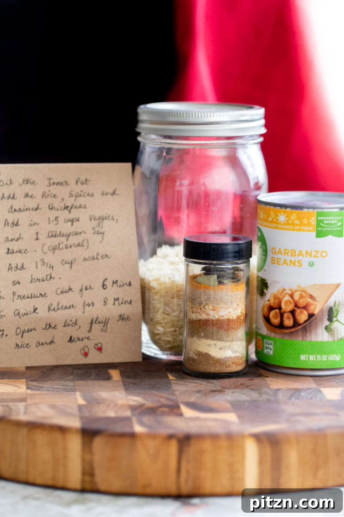 Instant Pot Curried Chickpea and Rice Mason Jar Meal 5 a recipe card, spice mix, can of chickpeas and a mason jar with rice on a wooden board