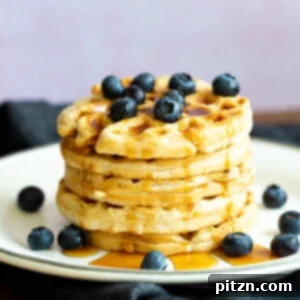 Our Easy Vegan Waffles stacked on a white plate over black napkin