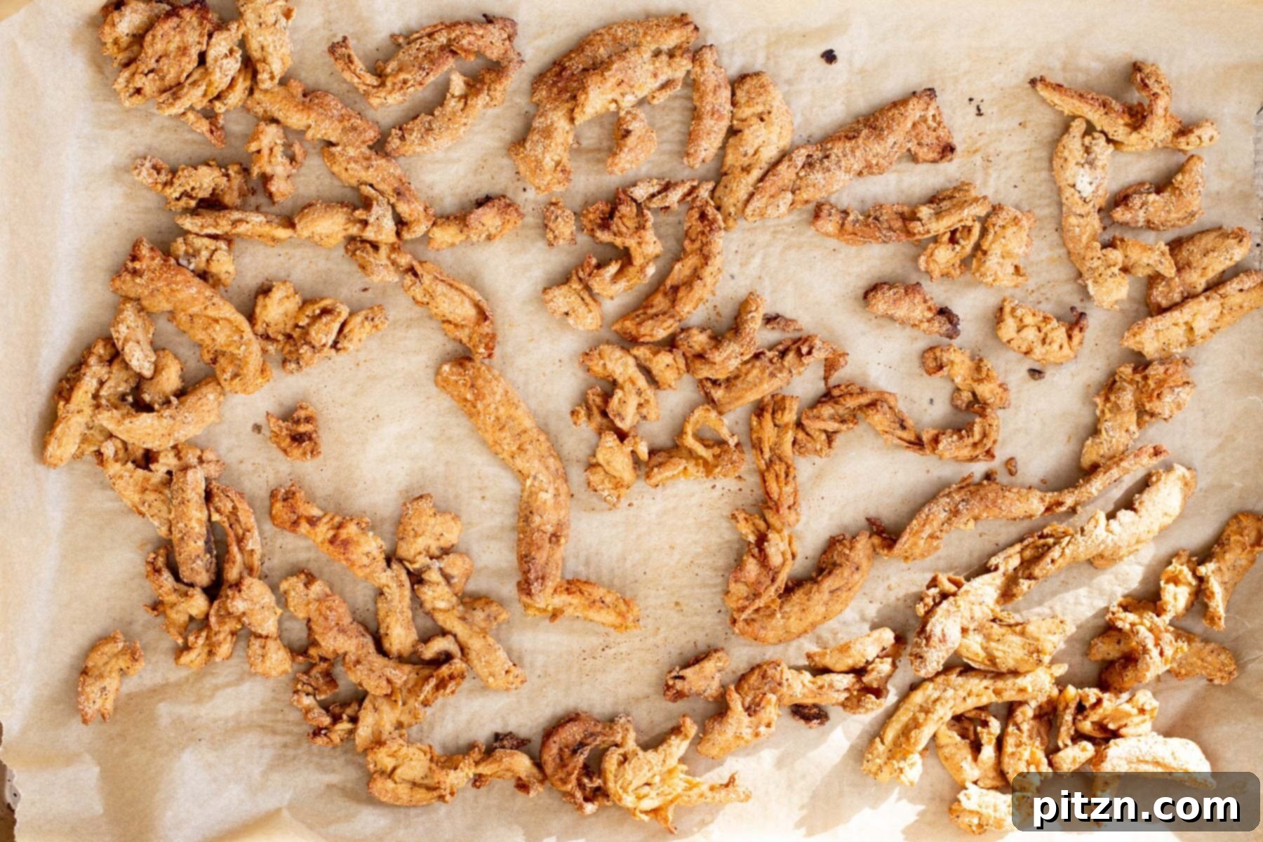 Soycurls spread evenly on a parchment-lined baking sheet, ready to be baked to crispy perfection.