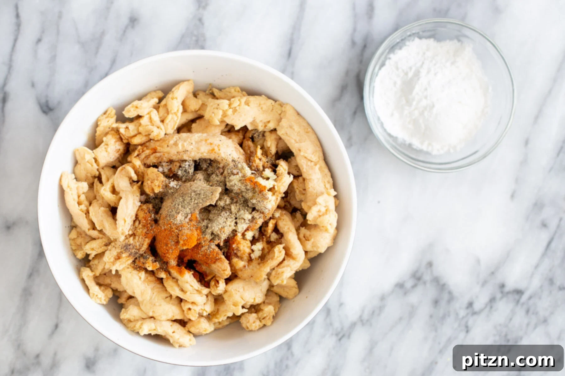 Rehydrated soycurls, generously sprinkled with a vibrant blend of Indian spices, ready for marination.