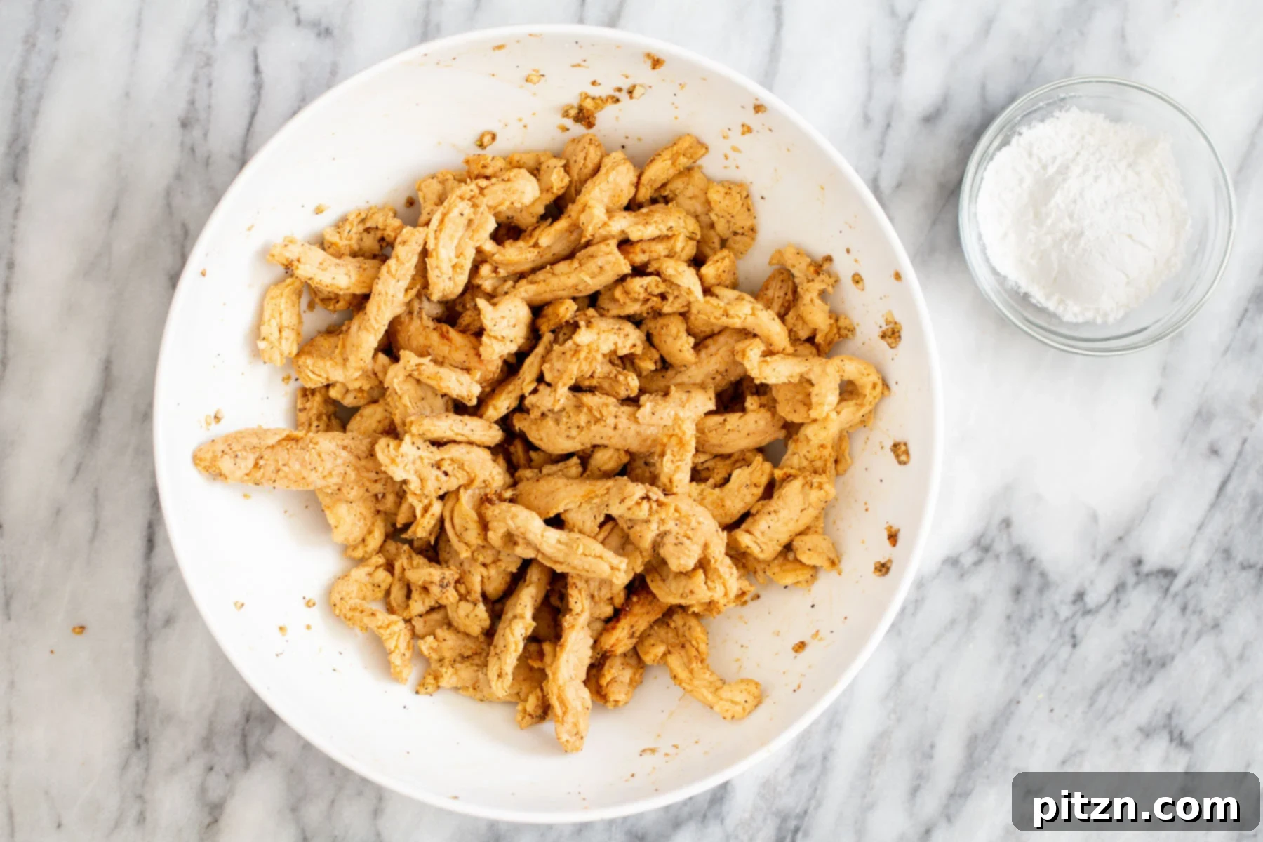 Squeezed and rehydrated soycurls resting in a bowl, awaiting the addition of spices for their flavorful marinade.