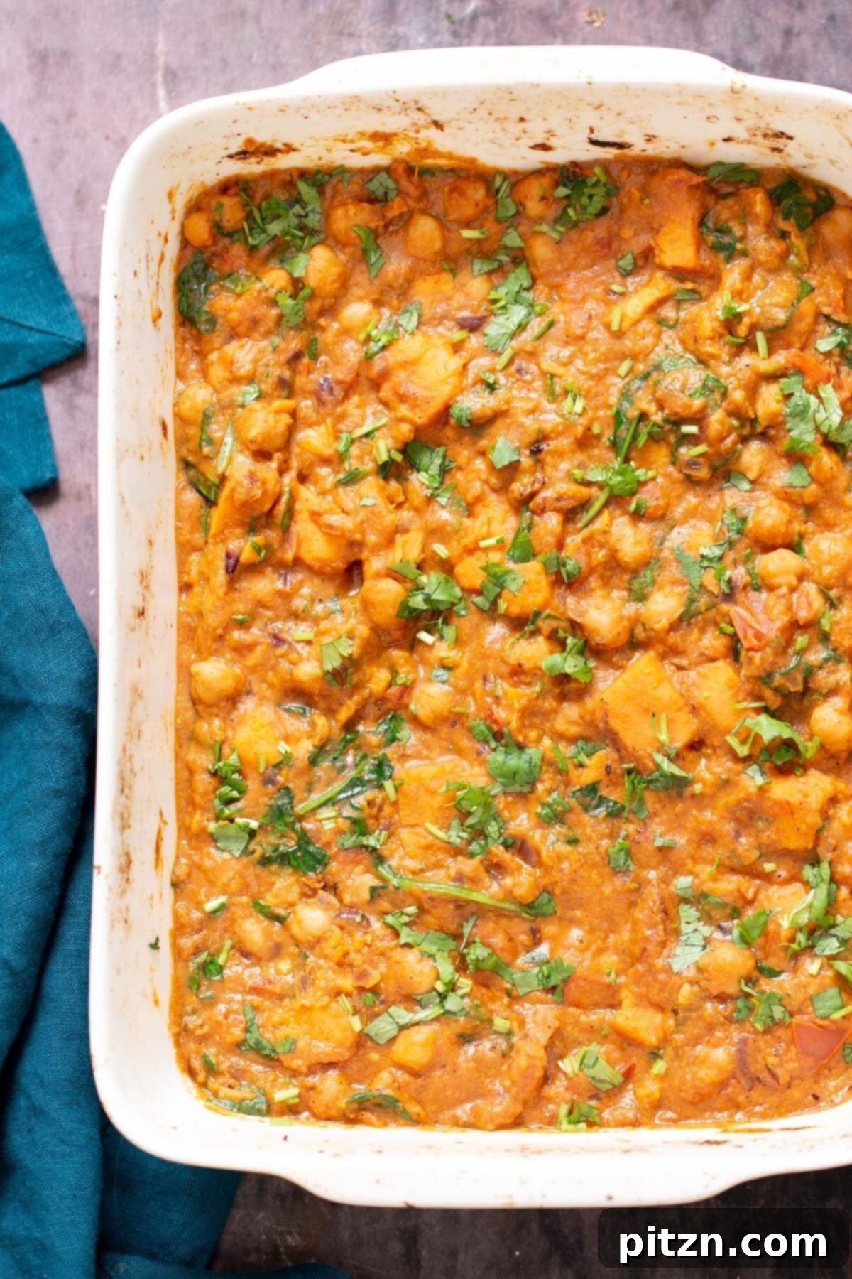 Sweet Potato and Chickpea Curry Bake 13 Top-down view of a casserole dish brimming with richly colored chickpea sweet potato curry, beautifully garnished and ready to serve