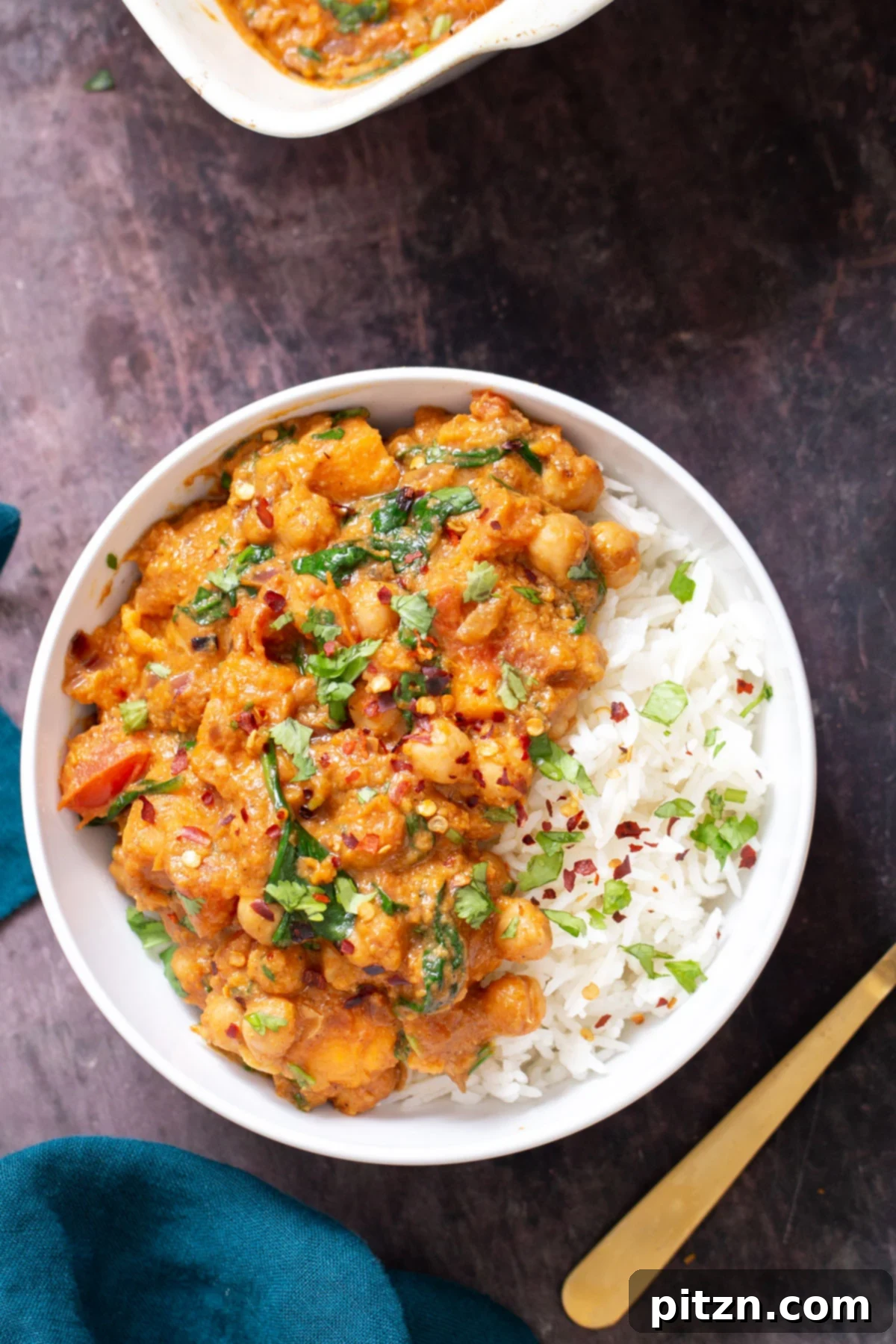 Sweet Potato and Chickpea Curry Bake 14 A generous serving of vegan baked sweet potato chickpea curry with white rice, beautifully sprinkled with fresh cilantro in a clean white bowl