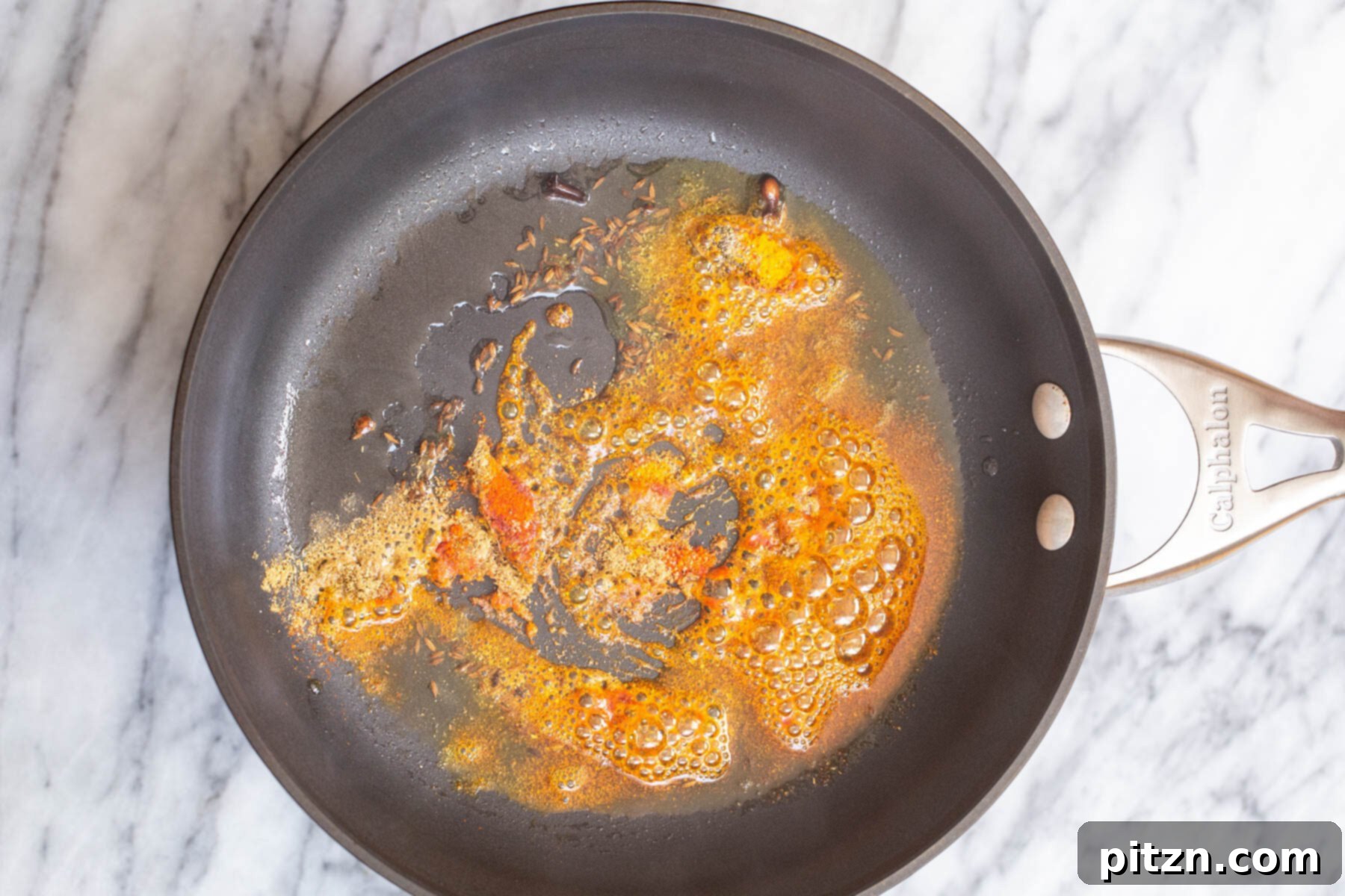 Spicy Black Gram Dal 8 Ground spices being added to the tempering mixture in a skillet for urad dal