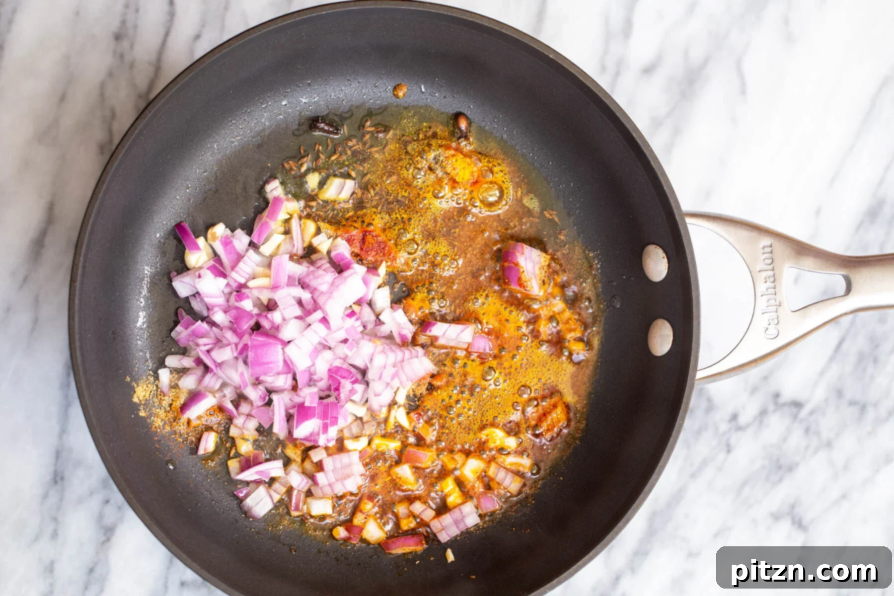 Spicy Black Gram Dal 9 Chopped red onion being introduced to the spice tempering in a skillet for urad dal