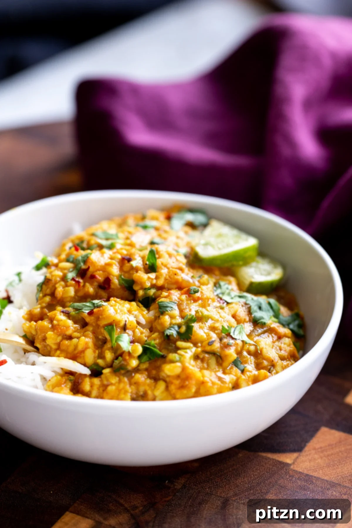 spicy urad dal A serving of spicy urad dal in a white ceramic bowl, garnished with fresh herbs