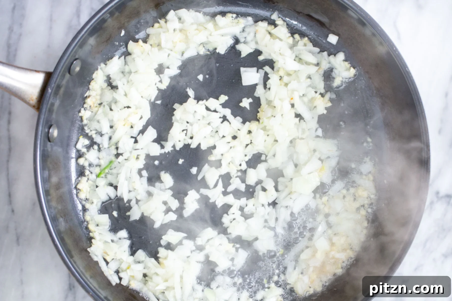 Effortless One-Pan Vegan White Lasagna with Tofu Bechamel 8 minced onion being sauteed in a skillet