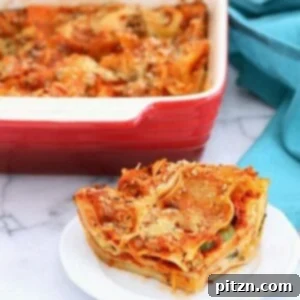 Close-up of a serving of Vegan Cauliflower Alfredo Spinach Artichoke Lasagna, garnished with fresh herbs.