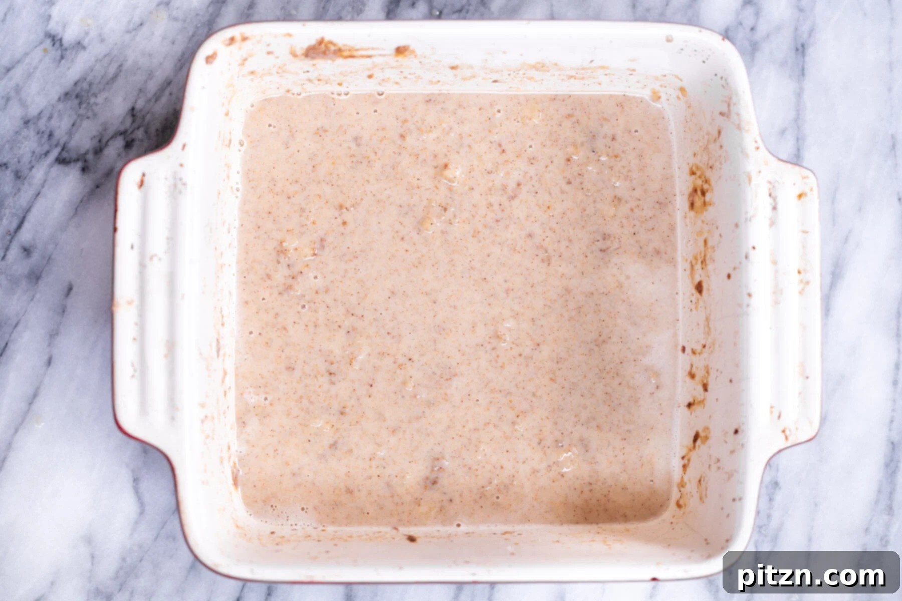 Cinnamon Streusel Vegan Banana Oat Squares 11 The fully mixed wet batter for banana oatmeal bars in a casserole dish, smooth and ready for dry ingredients.