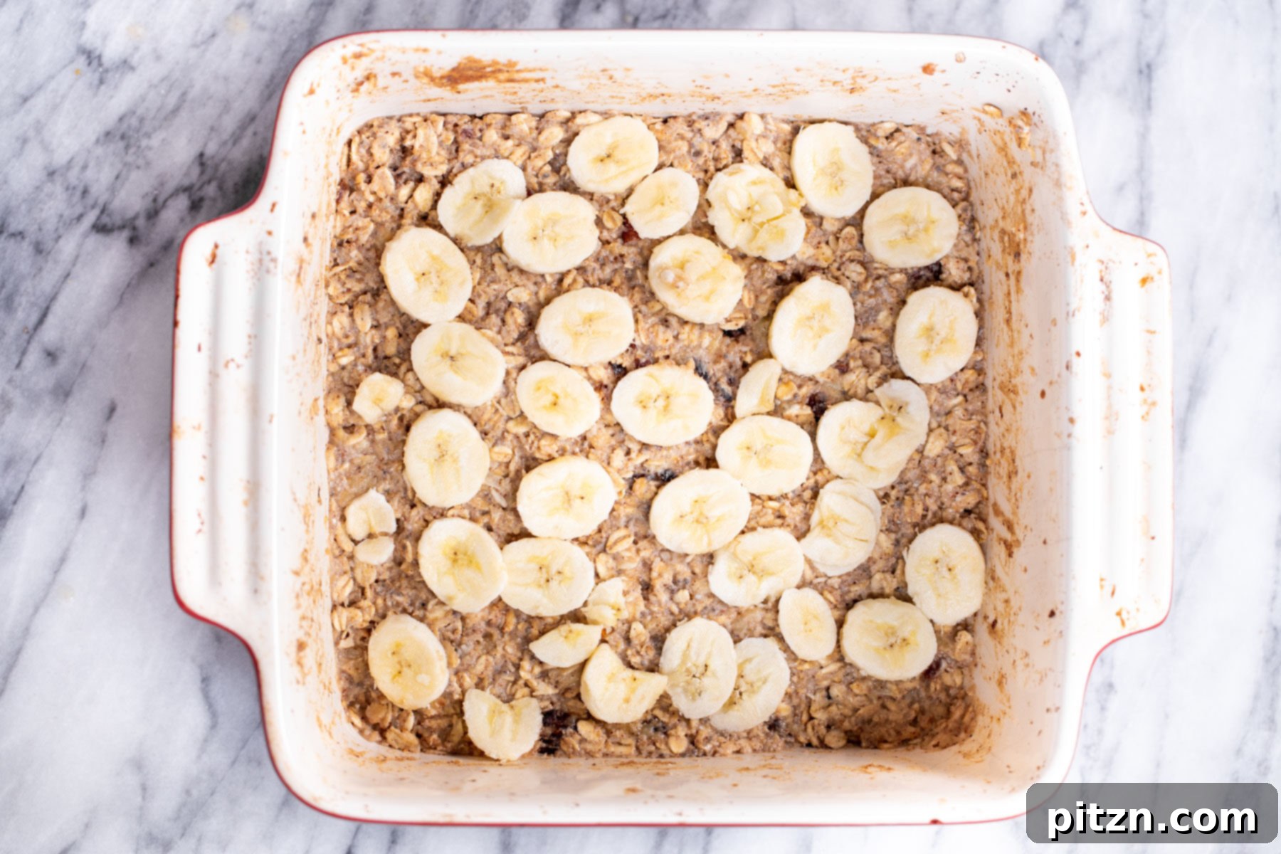 Cinnamon Streusel Vegan Banana Oat Squares 16 Beautifully arranged sliced bananas covering the oatmeal bar batter, ready for the cinnamon sugar sprinkle.