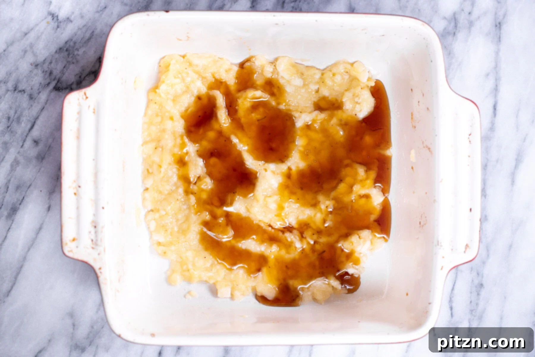 Cinnamon Streusel Vegan Banana Oat Squares 6 A stream of golden maple syrup being poured into mashed bananas, creating a sweet and flavorful base for the oatmeal bars.