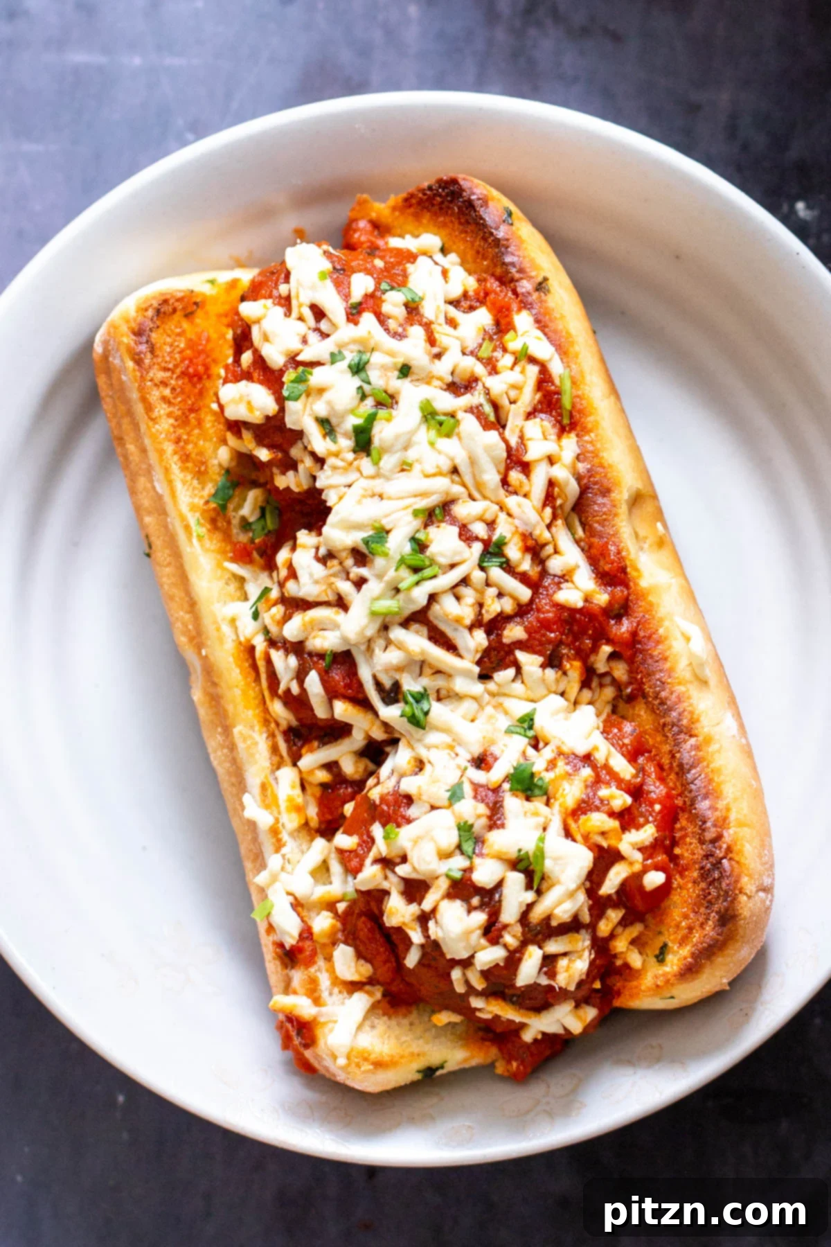 Classic vegan meatball sub topped with savory lentil meatballs, rich marinara sauce, and shredded vegan mozzarella cheese