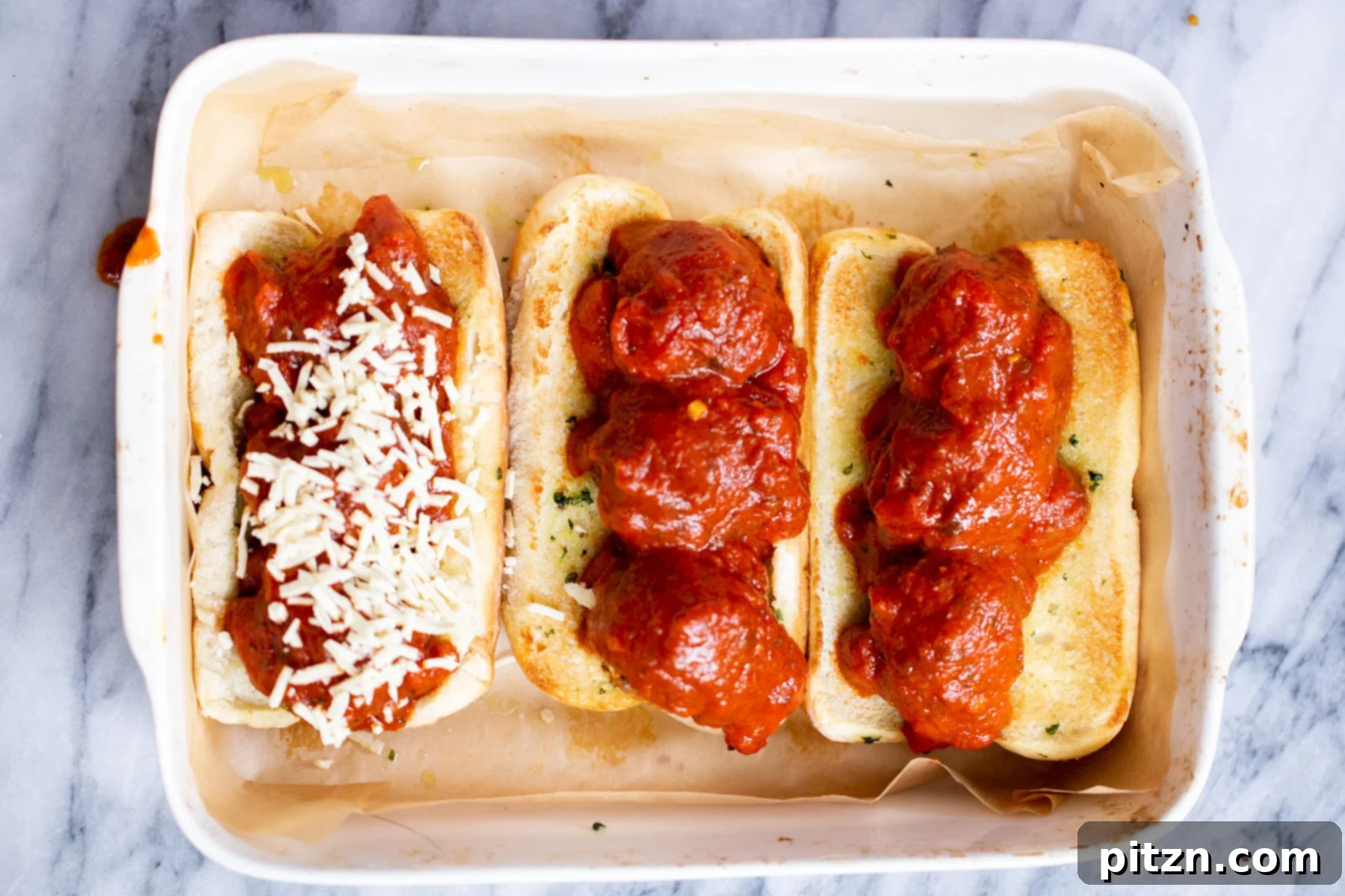 Close-up of vegan meatball subs with marinara sauce and shredded vegan cheese, ready for the final broil