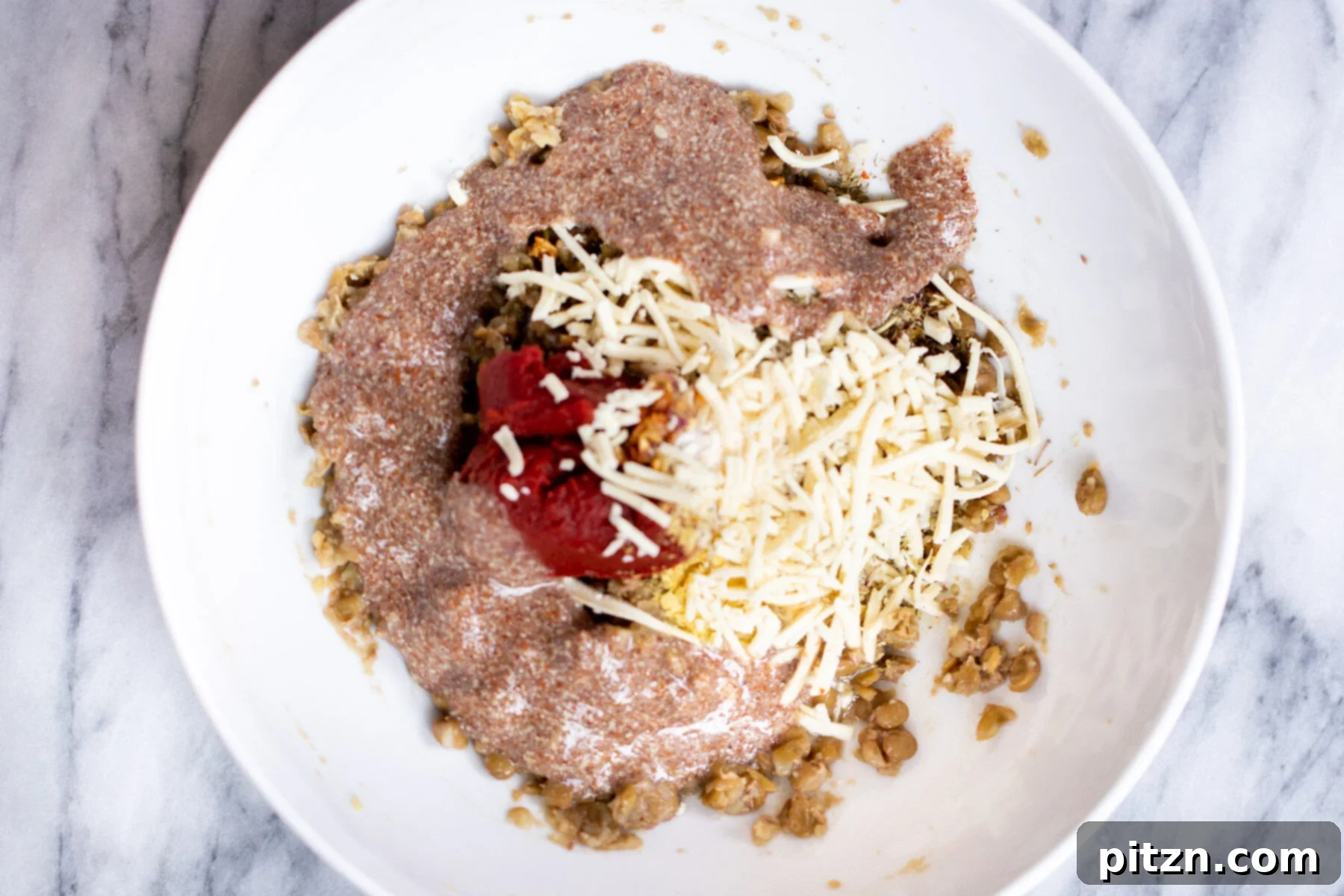 A bowl of mixed vegan lentil meatball ingredients, showcasing the perfect consistency before rolling