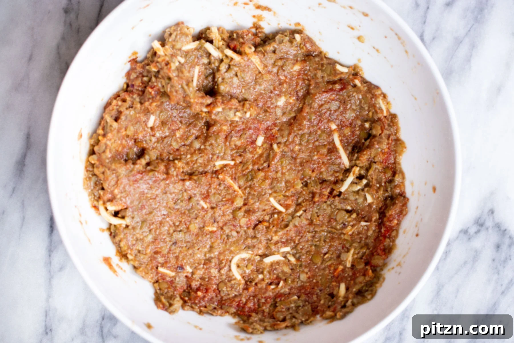Close-up of the vegan meatball mixture in a bowl, showing the texture and herbs