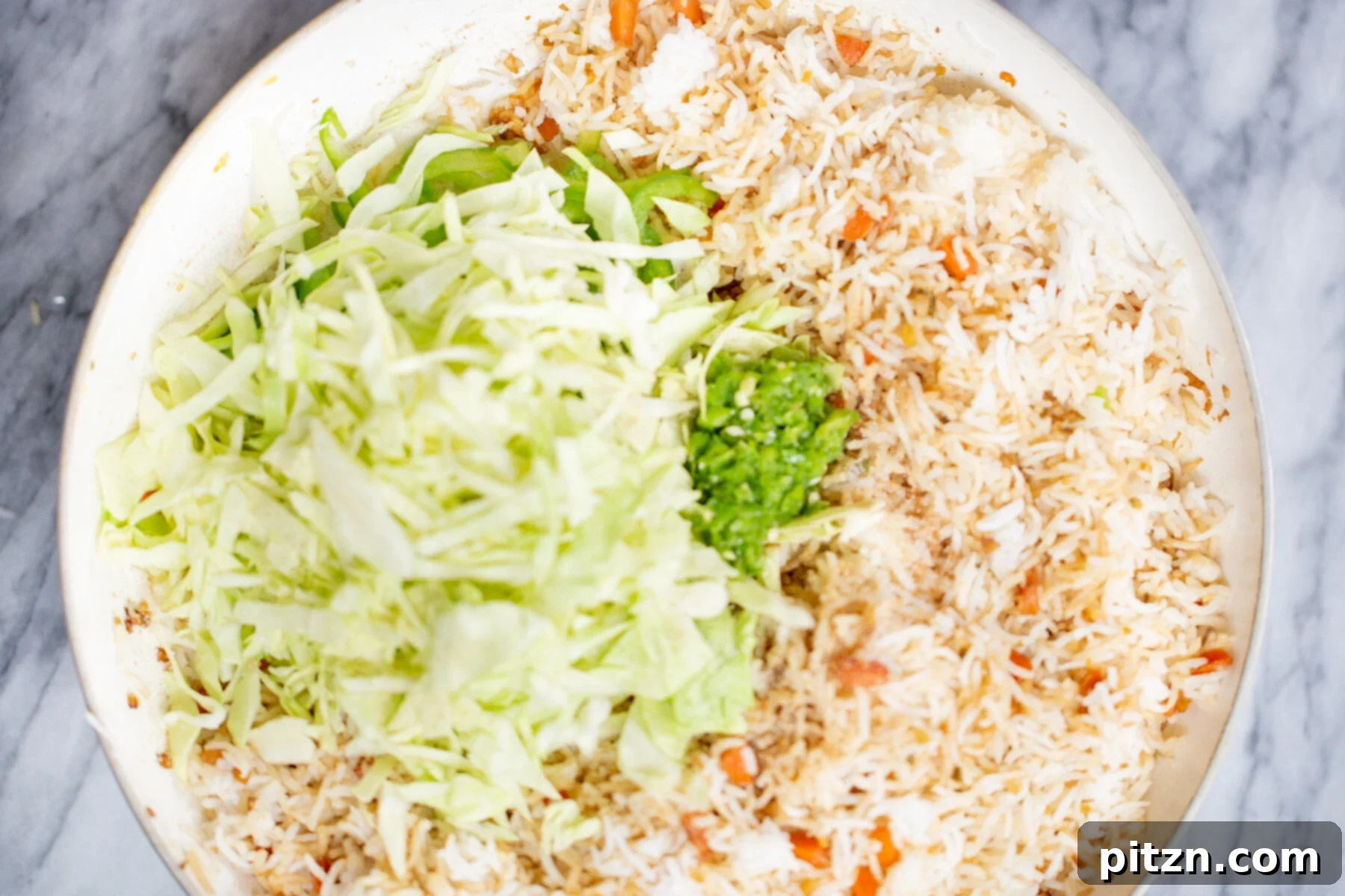 Indo-Chinese Fried Rice 11 Thinly shredded cabbage being added to a pan with partially cooked fried rice, ensuring its crispness is preserved.