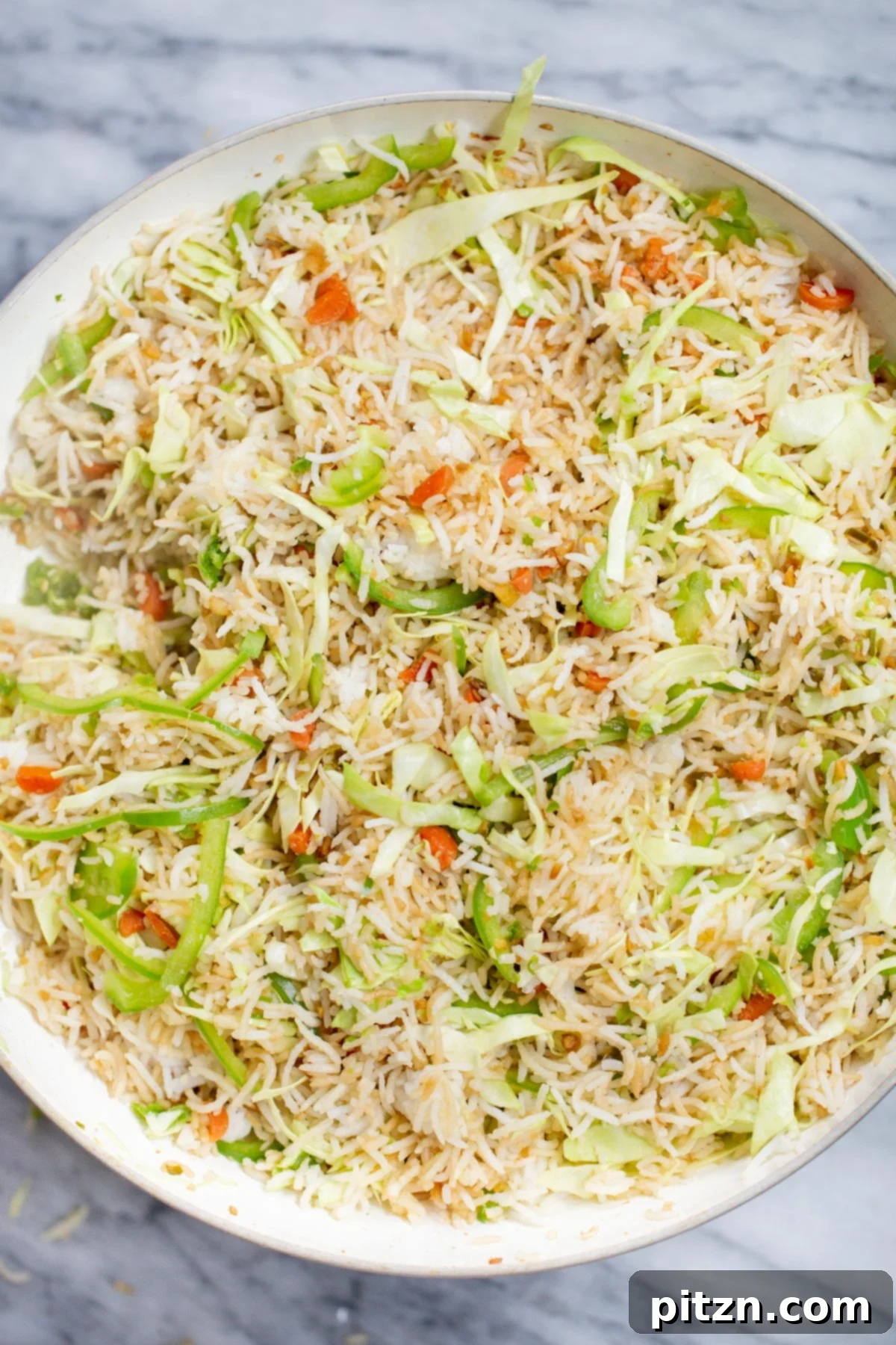Indo Chinese Fried Rice A close-up shot of the finished Indo-Chinese Fried Rice, vibrant with vegetables and perfectly seasoned, still in the sauté pan.