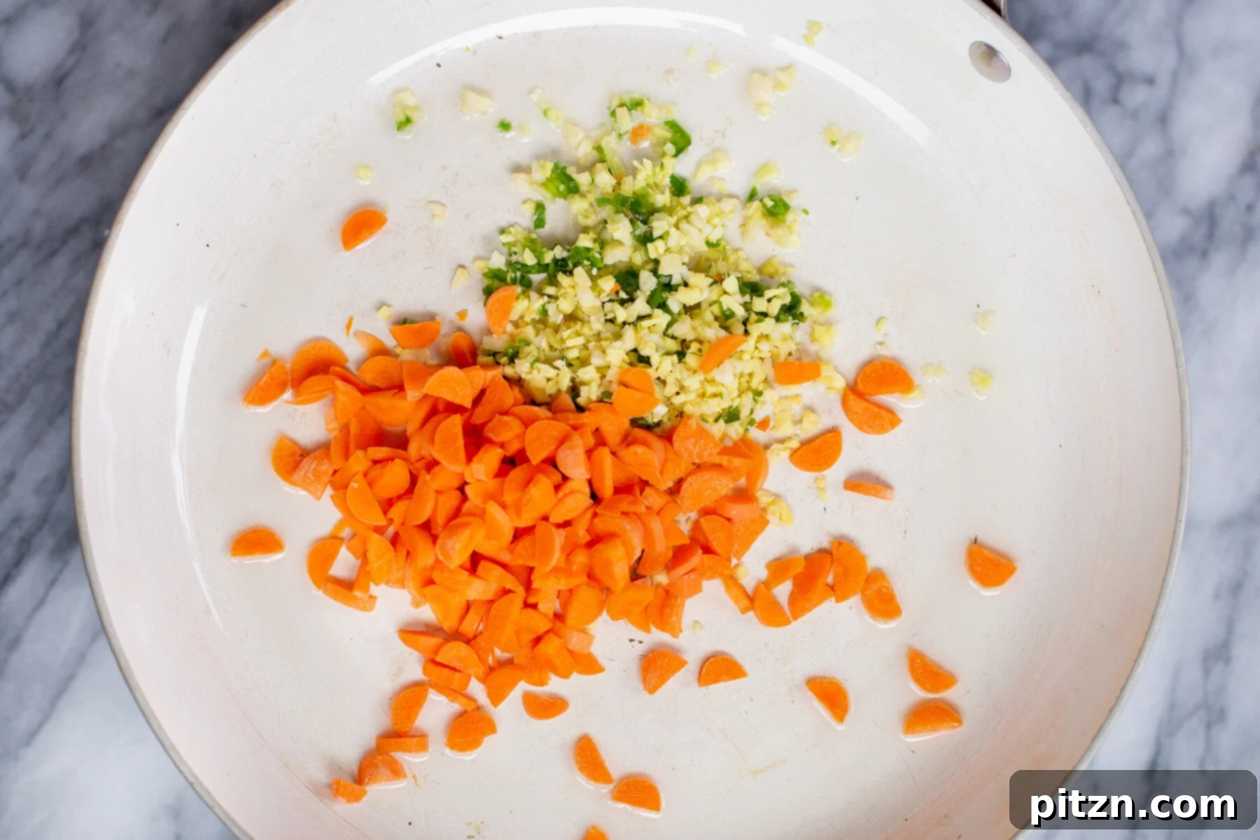 Indo-Chinese Fried Rice 6 Chopped carrots, ginger, and green chilies being sautéed in a pan, preparing the flavorful base for Indo-Chinese Fried Rice.