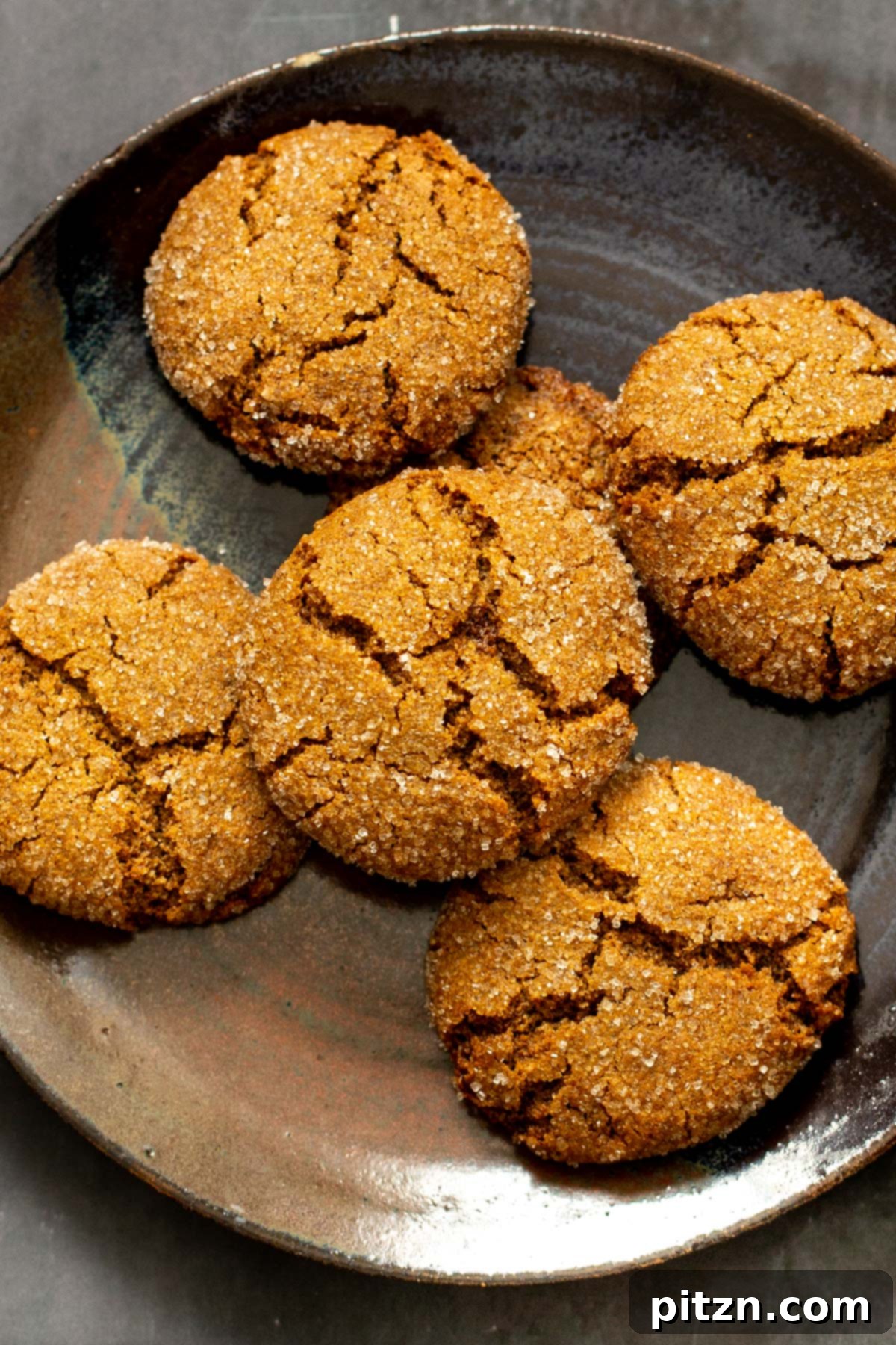 A charming plate overflowing with baked vegan gingerbread cookies, showcasing their perfect texture and inviting golden-brown color.