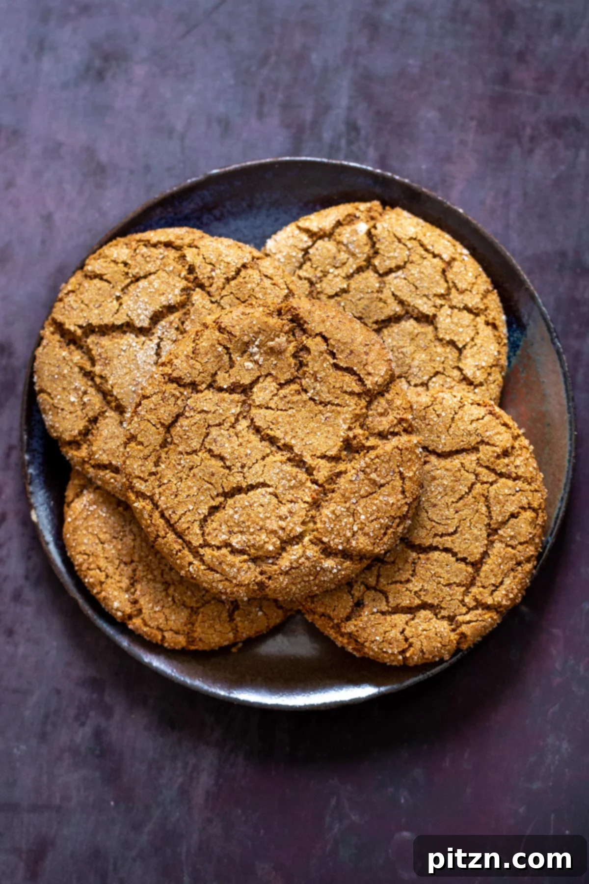 A generous serving of large, beautifully crinkled almond flour ginger cookies on an elegant platter, perfect for sharing. Grain-free and vegan goodness.