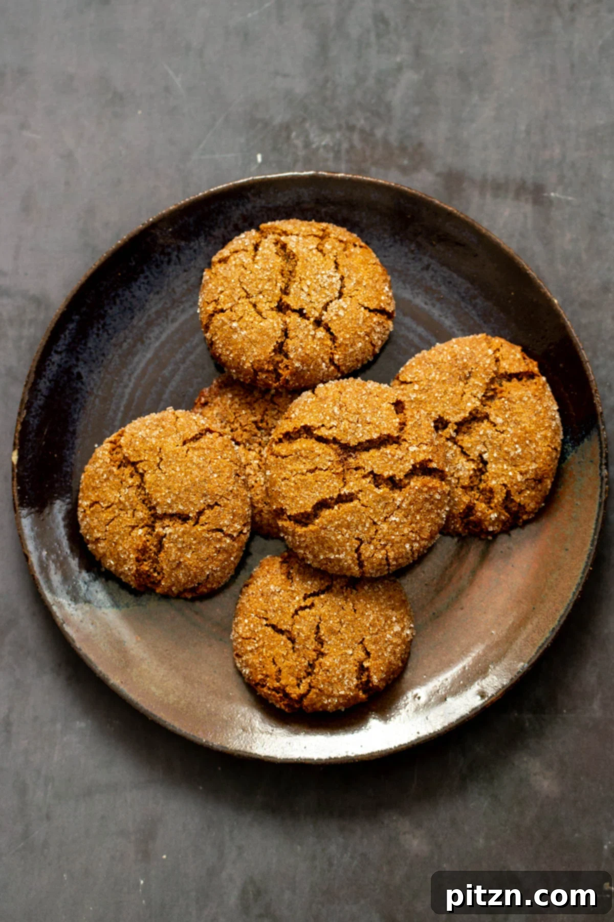 A plate brimming with soft spiced almond flour ginger cookies, each with delightful crinkly tops, highlighting their inviting texture. Grain-Free & Gluten-free