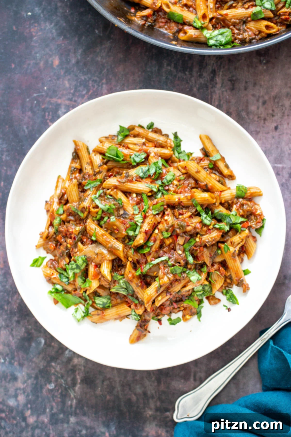 A serving of One-Pan Veggie Pasta on a white plate, showcasing its rich vegetable sauce.