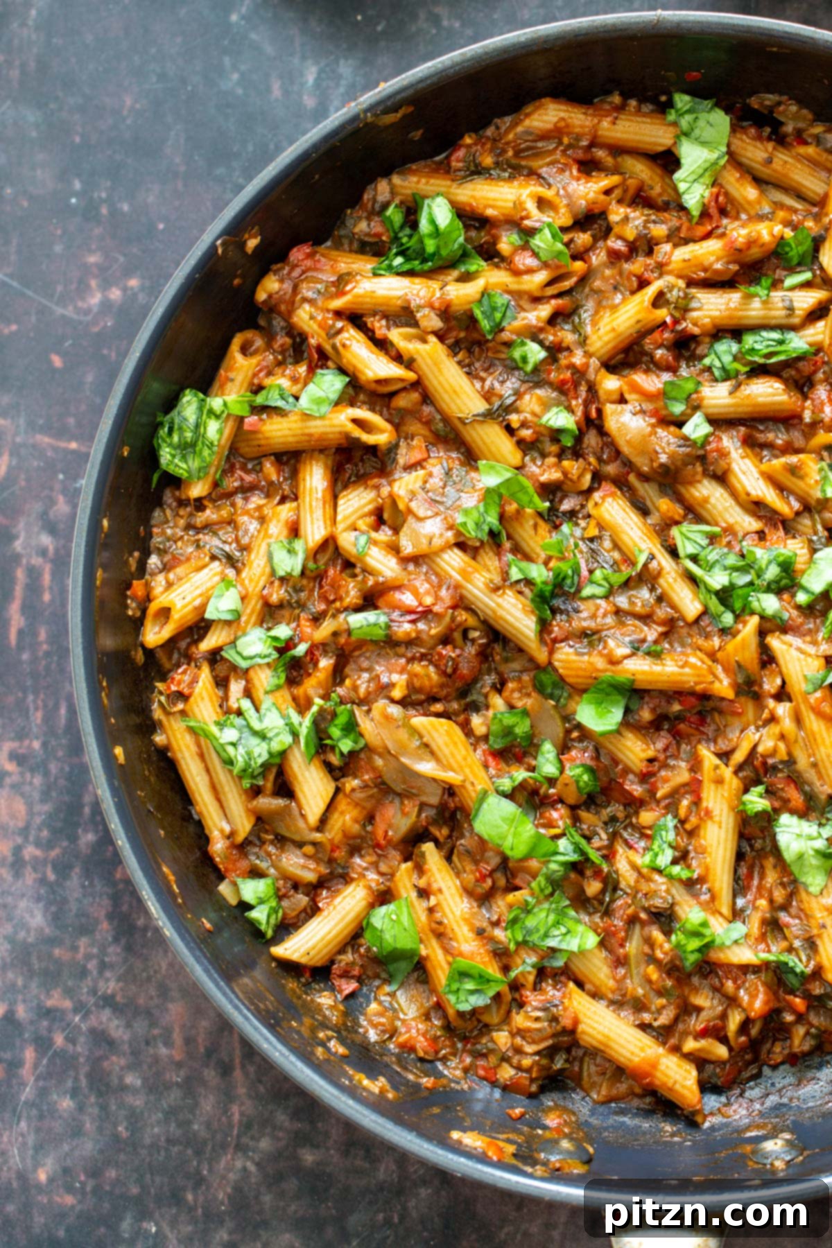 One-Pan Veggie Pasta with walnuts, sun-dried tomatoes, and basil simmering in a pan.