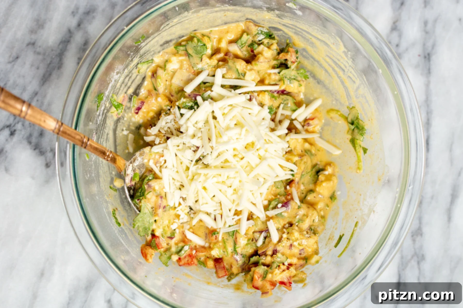 Savory Chickpea Flour Breakfast Combo 10 Shredded vegan cheese being folded into chickpea flour pancake batter in a glass bowl