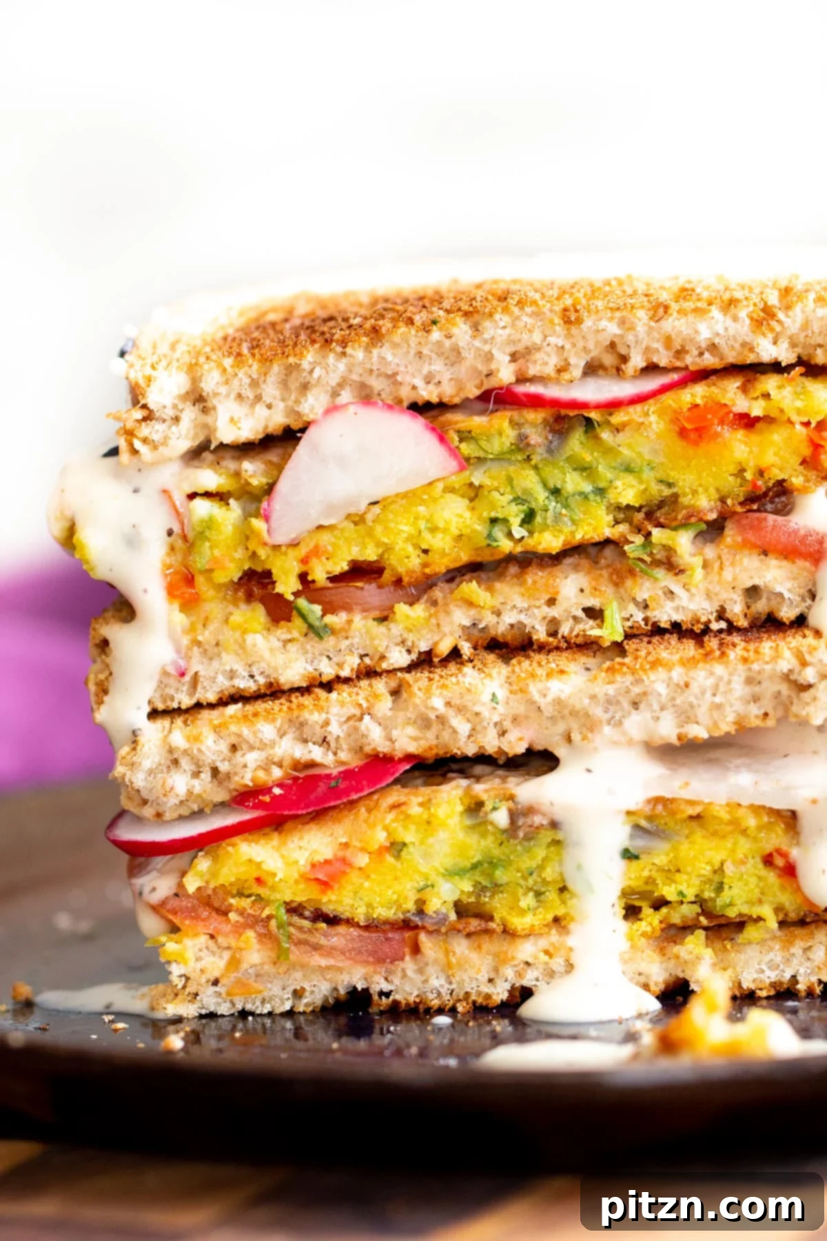 Savory Chickpea Flour Breakfast Combo 3 Stacked vegan breakfast sandwich filled with hearty chickpea flour pancakes and fresh vegetables