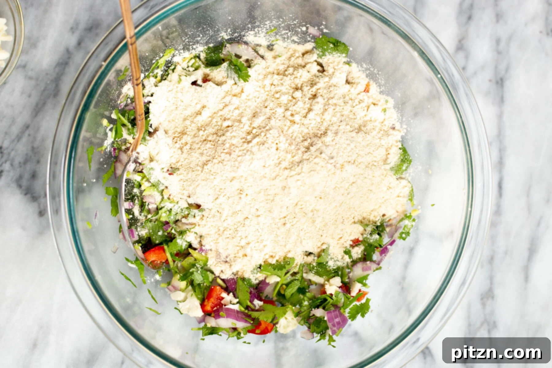 Savory Chickpea Flour Breakfast Combo 8 Adding chickpea flour to chopped veggies in a bowl for savory vegan pancakes