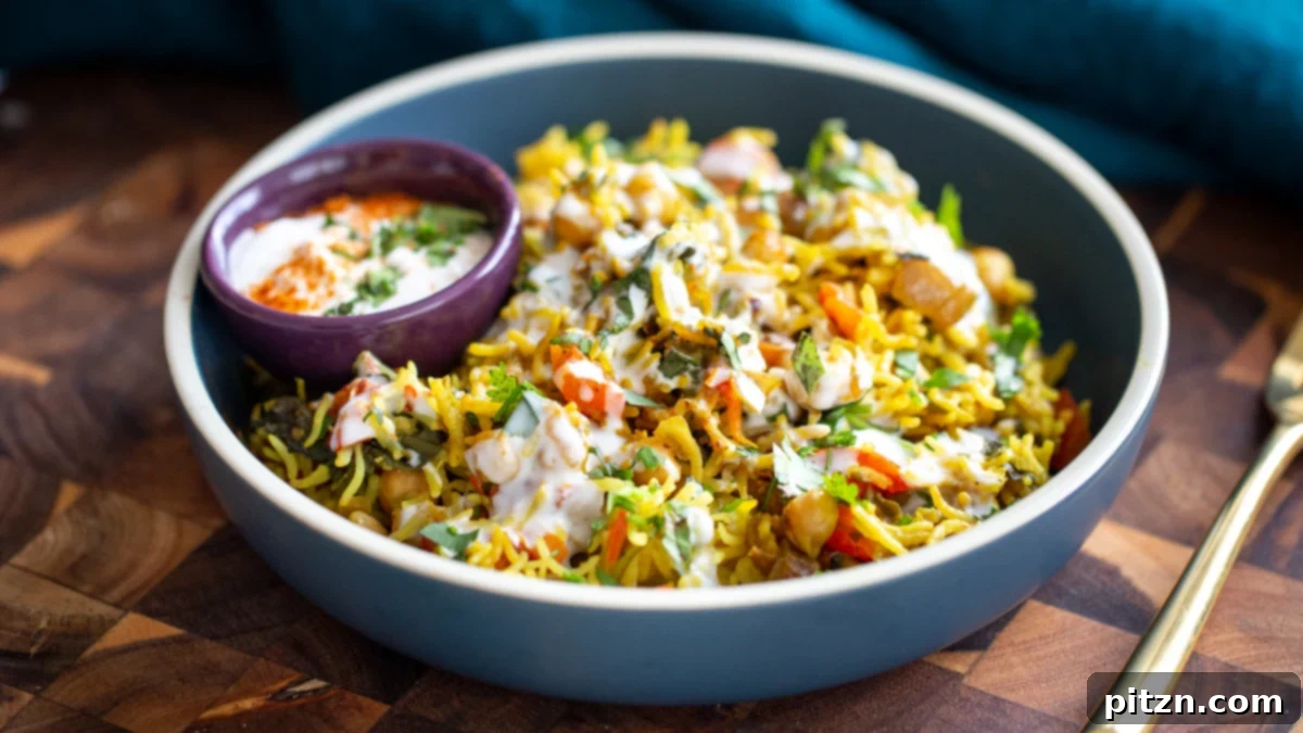 Golden Spiced Vegan Chickpea Rice Bake 13 A side view of a charming blue bowl, filled with fluffy chickpea rice pulao, artistically drizzled with a creamy raita.