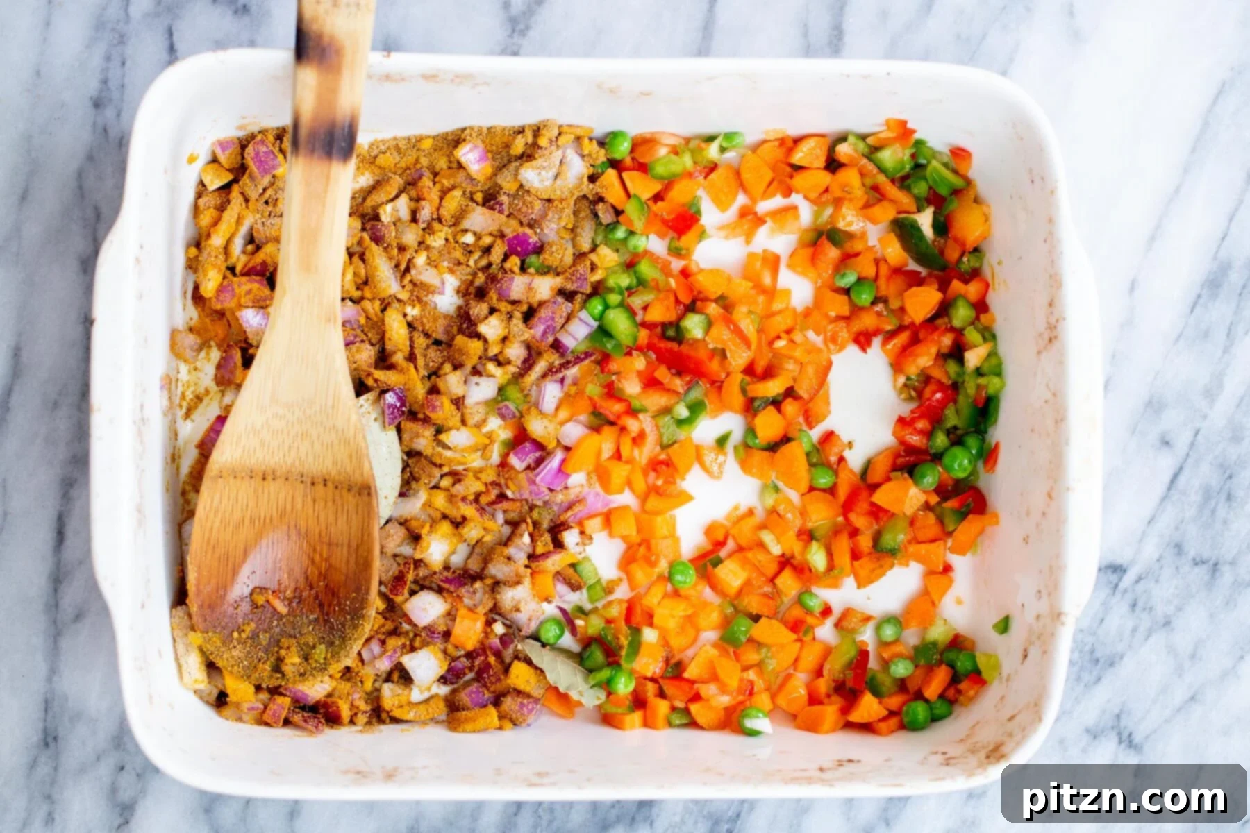 Golden Spiced Vegan Chickpea Rice Bake 7 A casserole dish showing spices being mixed into finely chopped onion and garlic, forming the aromatic base of the pulao.