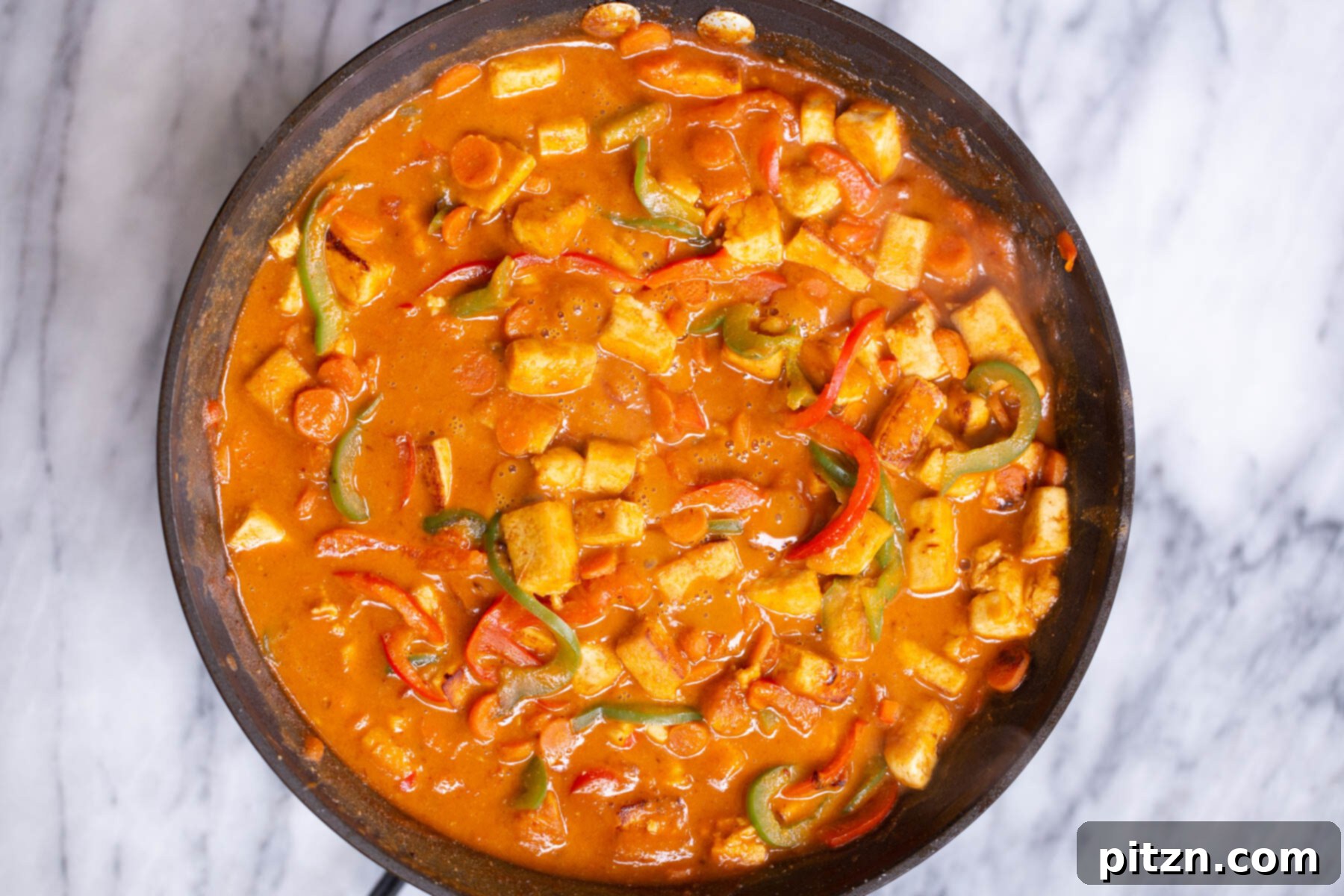 tofu cubes and sauteed bell peppers in creamy peanut butter sauce 